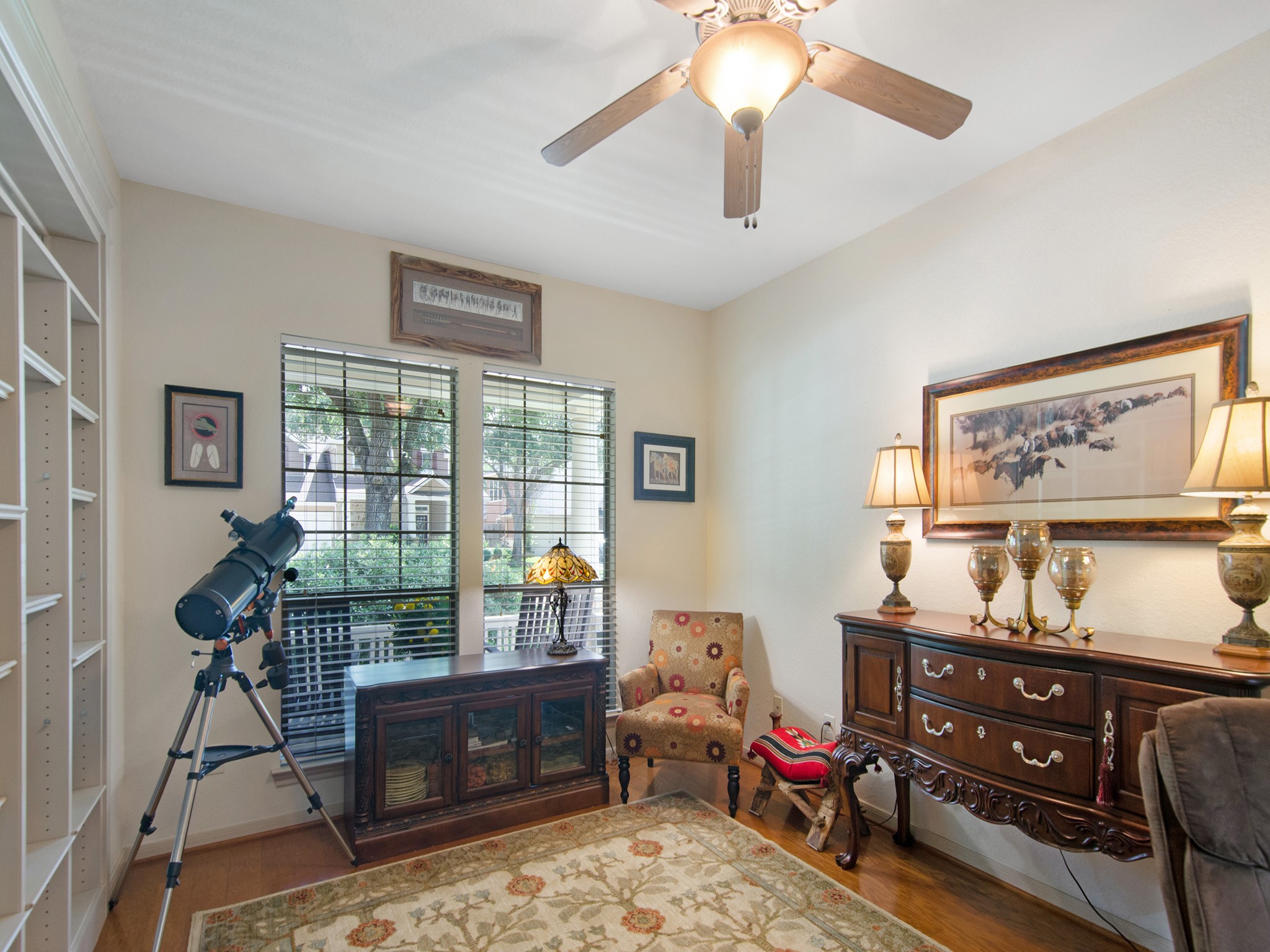 Warm wood flooring and front-facing windows overlooking the cozy front porch create a comfortable and inspiring workspace.