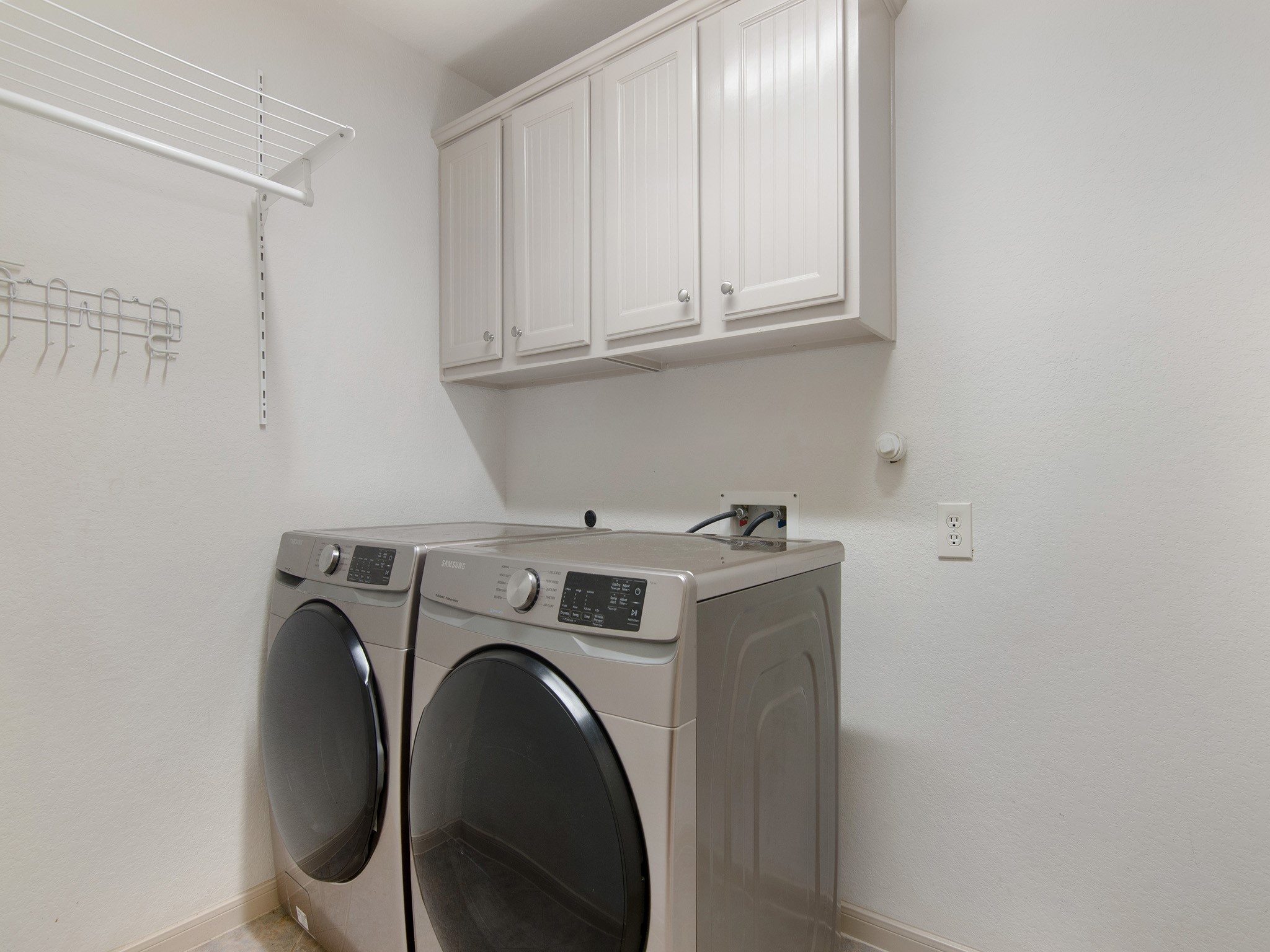 Well placed laundry room with added storage, just steps away from the primary bedroom.