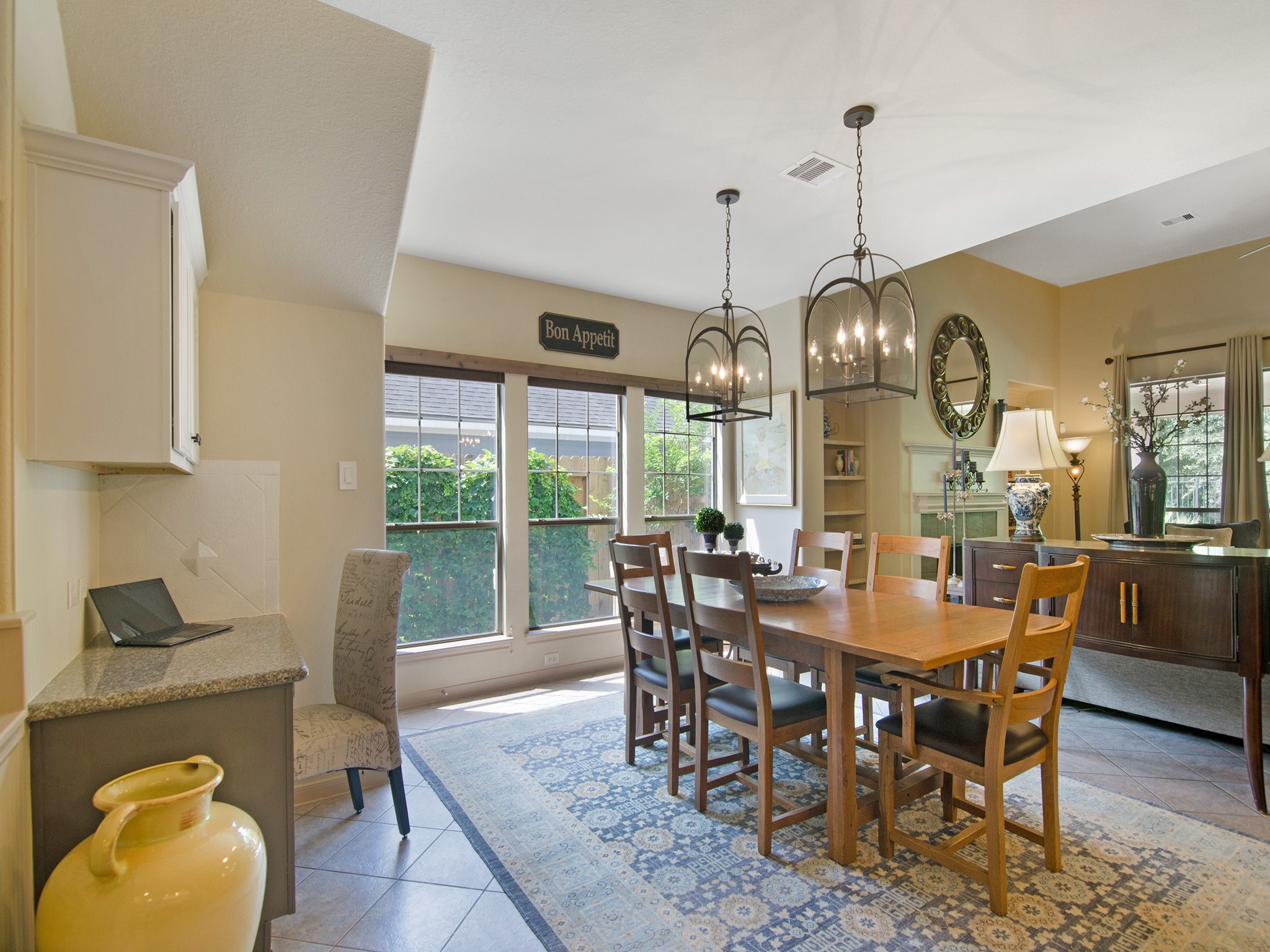 A wall of windows fills the dining space with natural light while the built-in desk and cabinetry provide a convenient space for household organization, homework or a home command center.