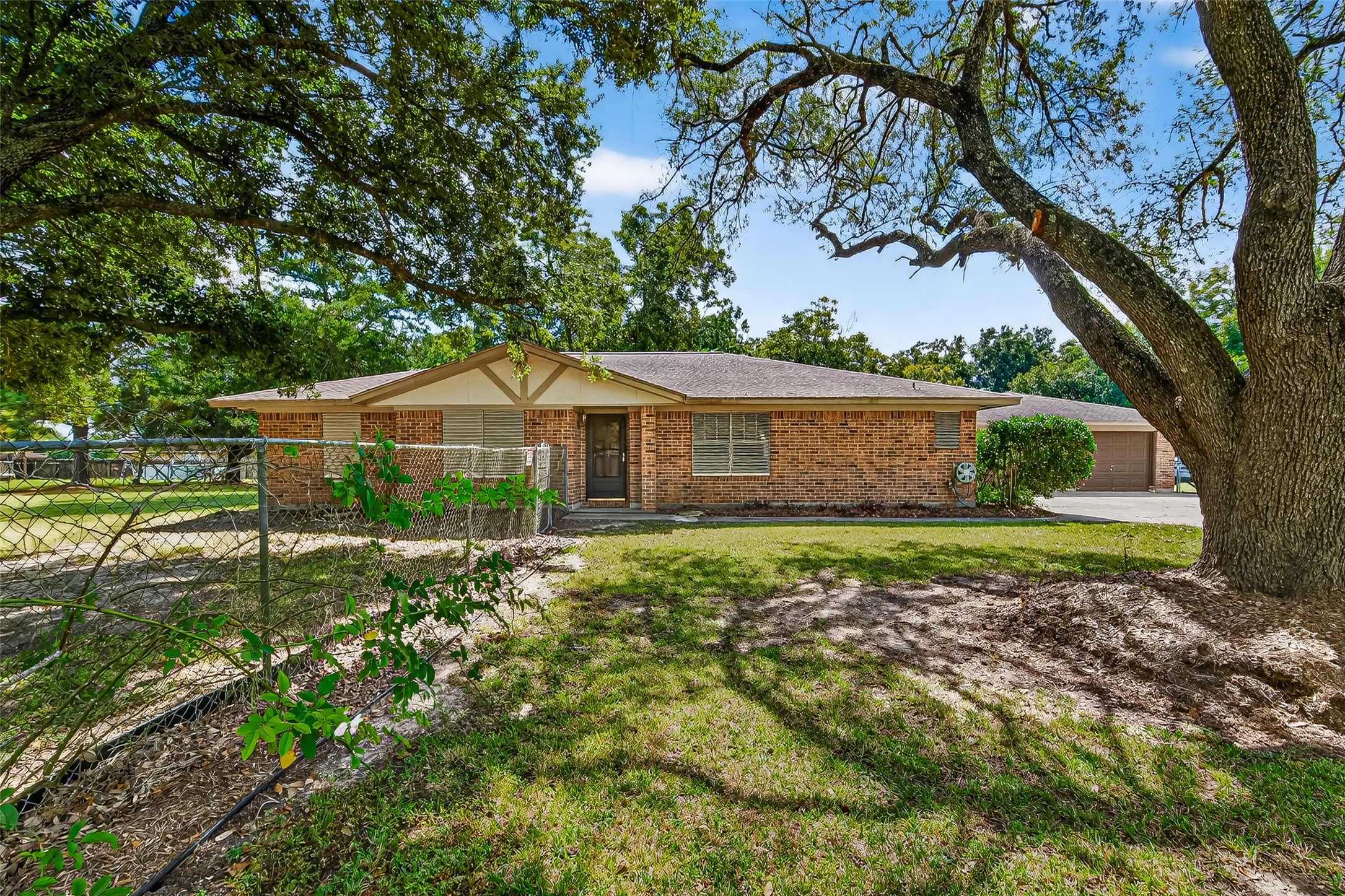 Charming brick ranch-style home with a welcoming front entrance, nestled among mature trees. The spacious yard offers shade and privacy, perfect for outdoor activities. Ideal for those seeking a serene and inviting environment.