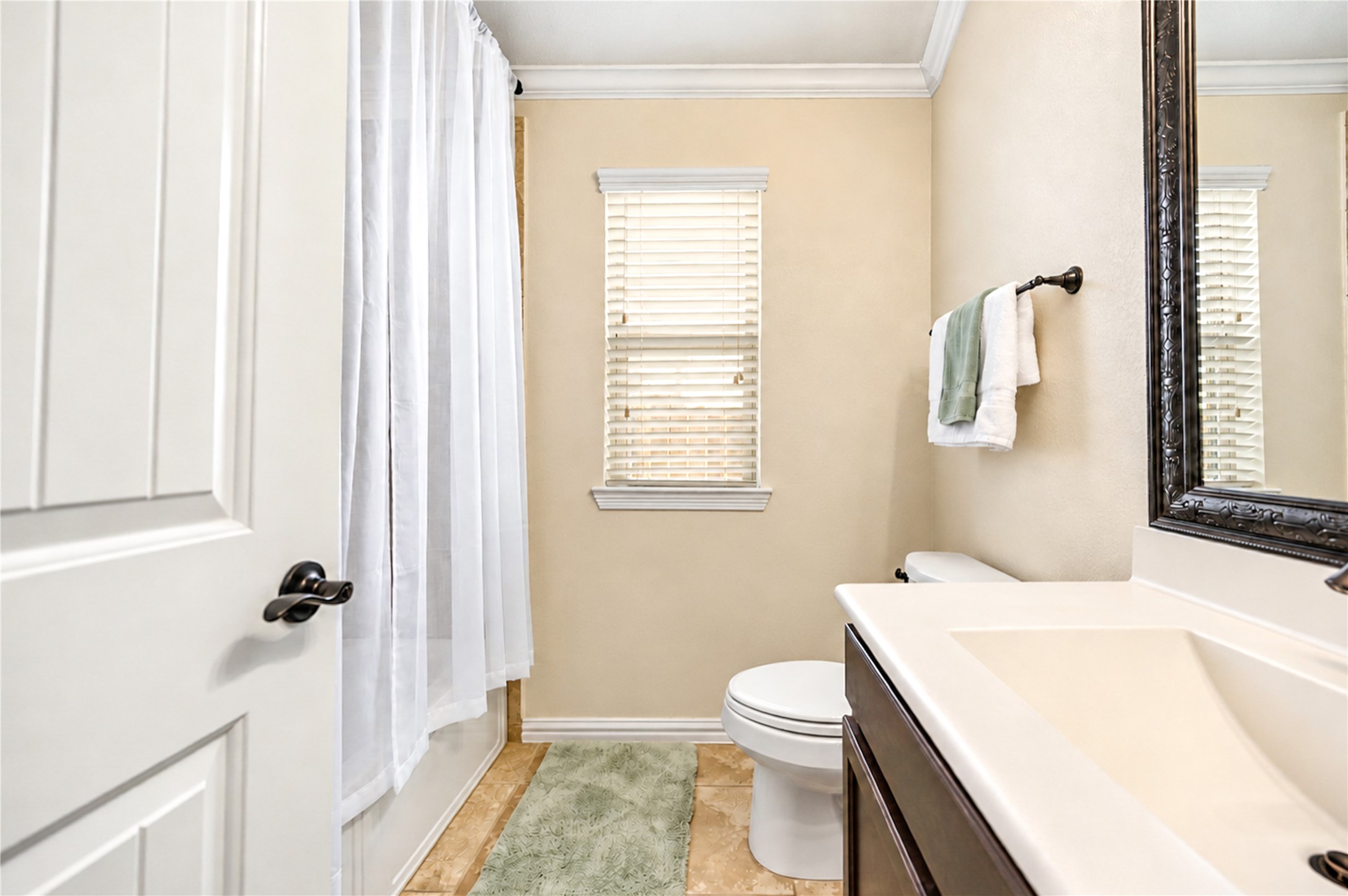 The secondary bath includes a tub and shower combination with a single vanity.