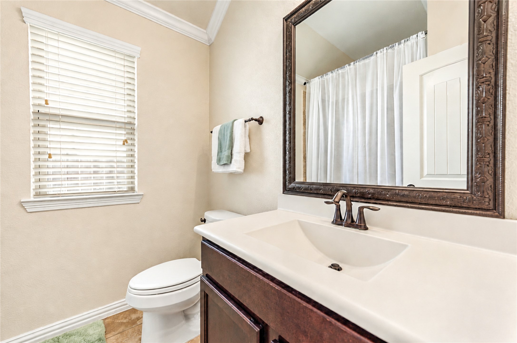 A cultured-marble vanity and a framed mirror complete the secondary bath.