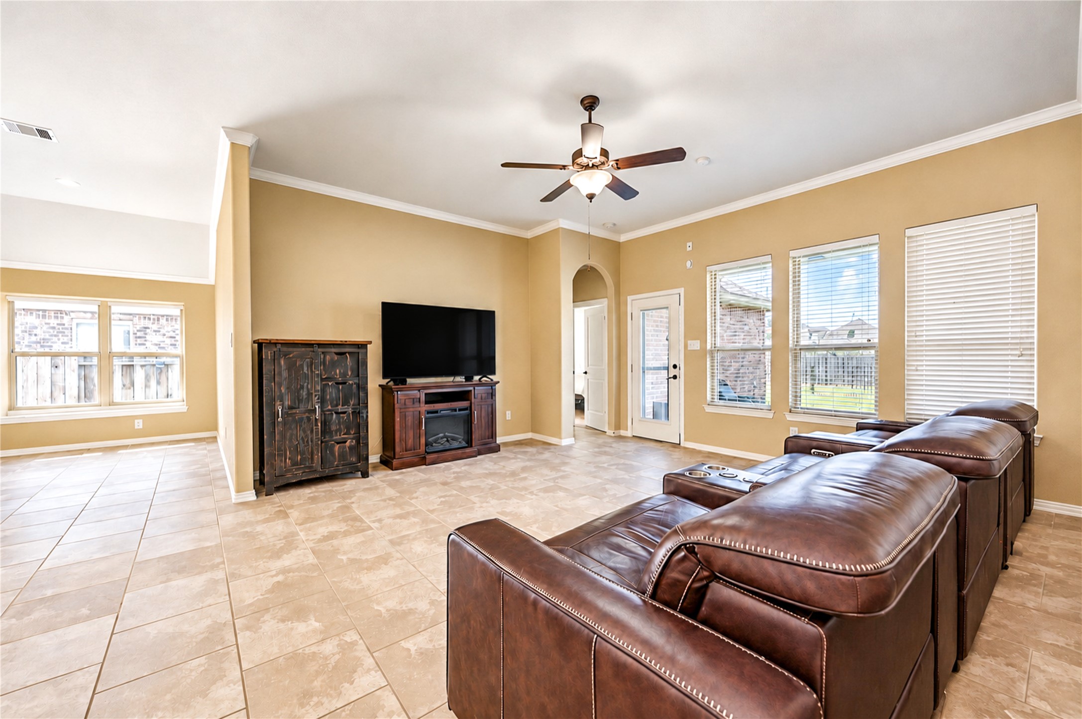 Large windows and a glass door bring natural light to the living room and its view of the backyard.