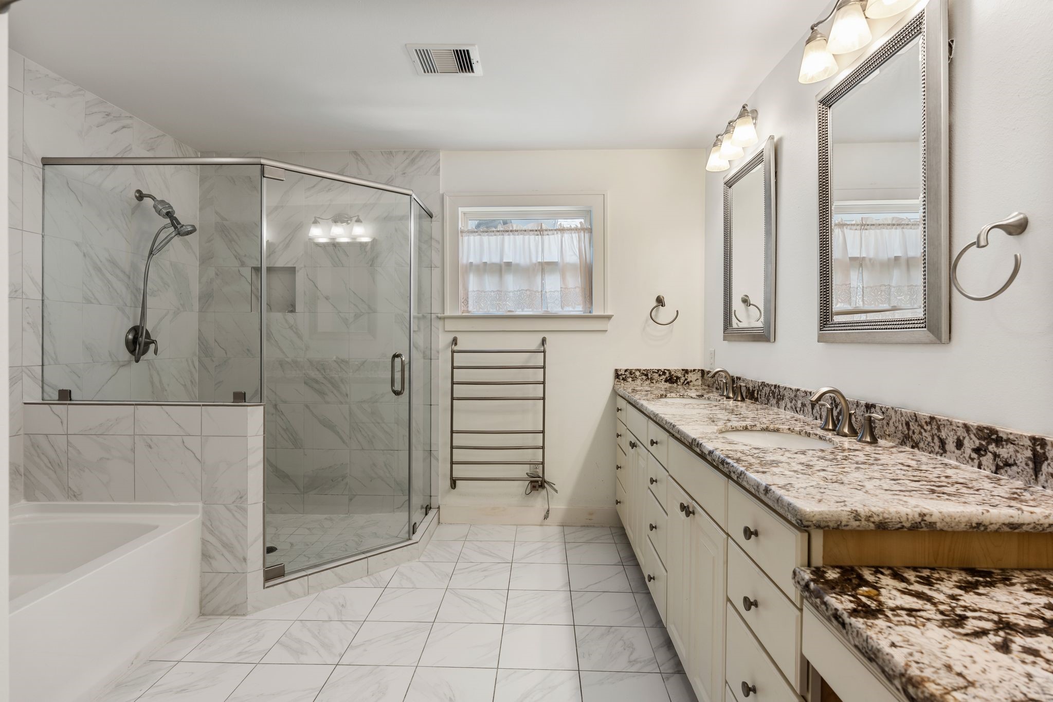 The modern primary bath features dual vanities and lots of storage.