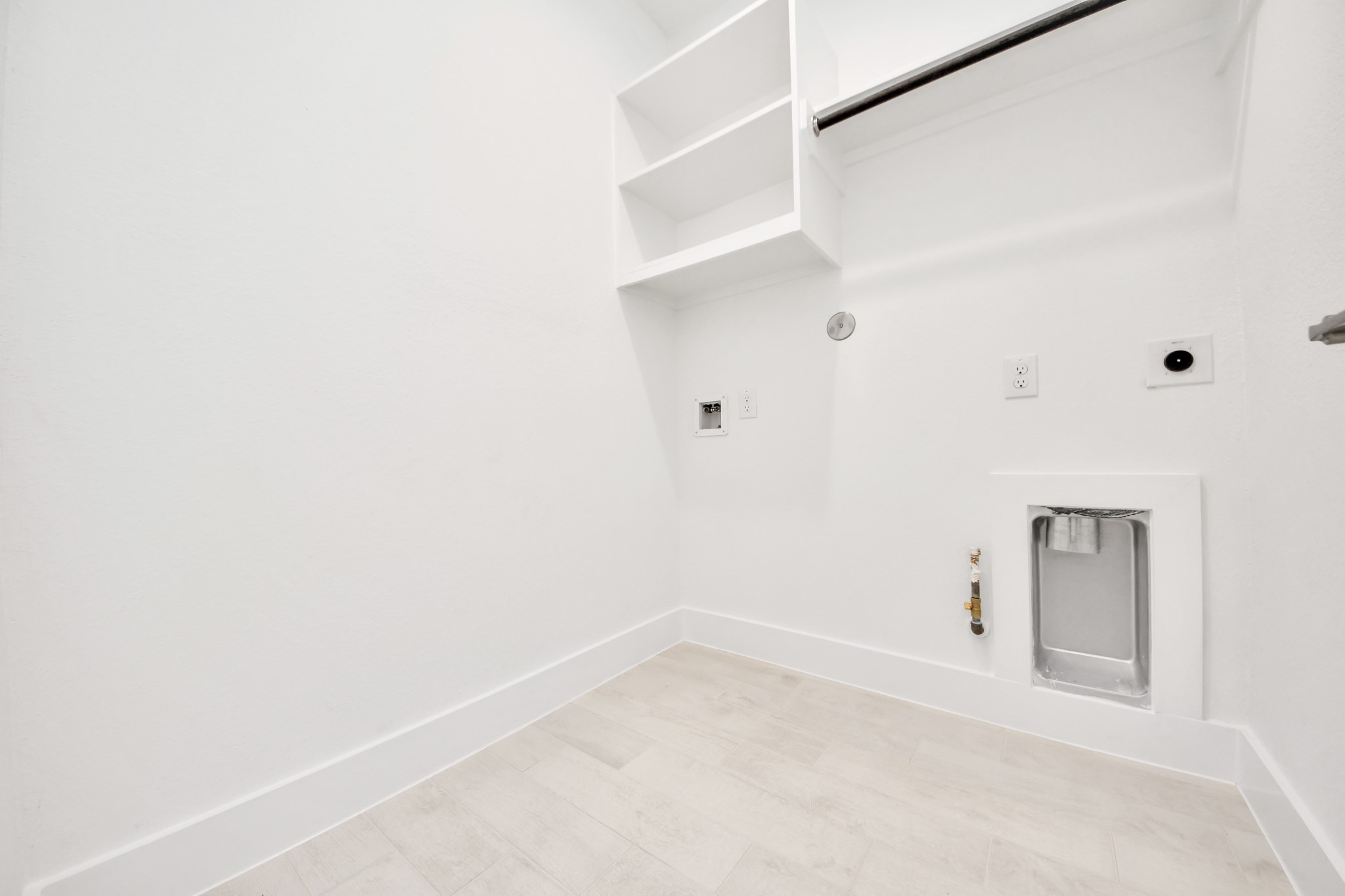 A perfect blend of functionality and comfort. Capture the essence of easy living with a first-floor laundry room, thoughtfully equipped with shelving for effortless organization. Both electric and gas connections available. Sample photo of completed home with similar floor plan. Actual colors and selections may vary.