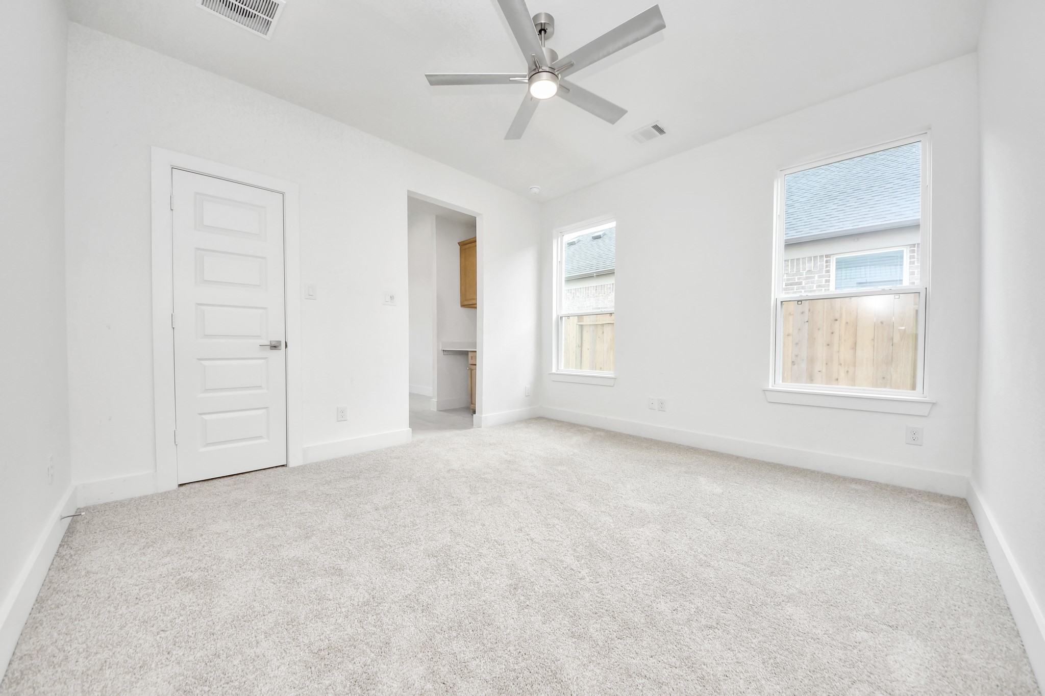 Secondary bedroom features plush carpeting, large windows that let in plenty of natural light, bright paint, and spacious closets. Sample photo of completed home with similar floor plan. Actual colors and selections may vary.
