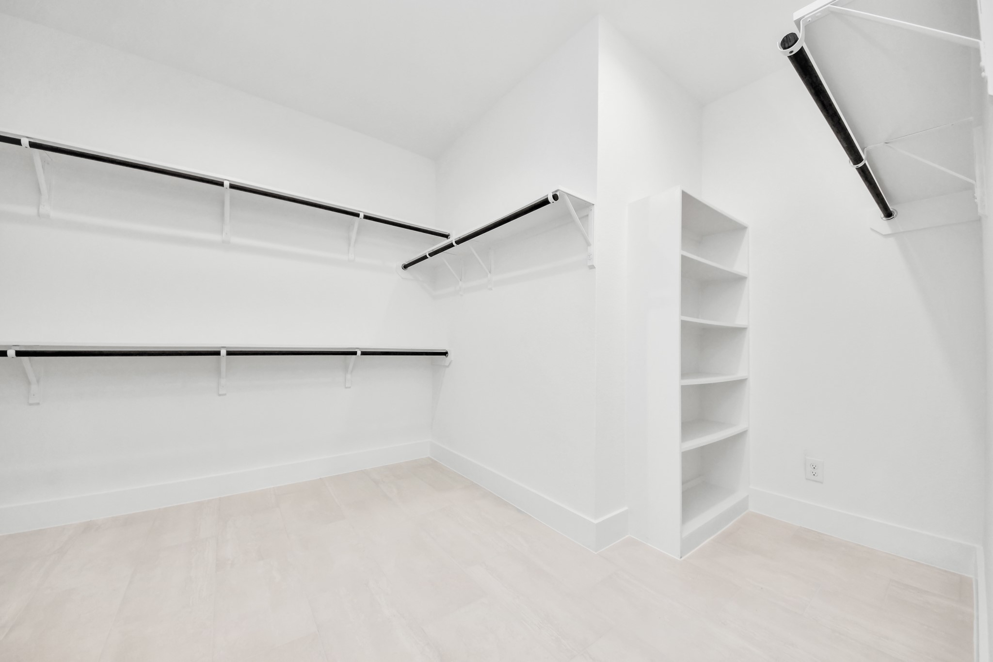 Walk-in closet that epitomizes luxury and practicality. This generously sized space features built-in shelving, offering abundant room for impeccable organization. High ceilings and recessed lighting create a bright and welcoming ambiance. Sample photo of completed home with similar floor plan. Actual colors and selections may vary.