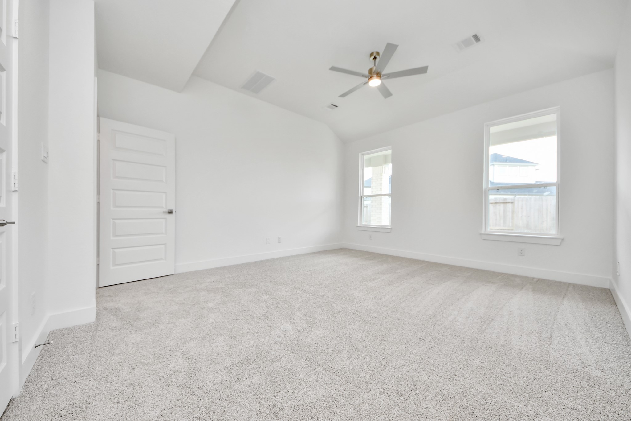 Retreat to the luxurious primary suite, your perfect escape for unwinding after a long day. Located on the first floor, this spacious room features plush carpeting, calming paint tones, high ceilings, and large windows with privacy blinds. Sample photo of completed home with similar floor plan. Actual colors and selections may vary.