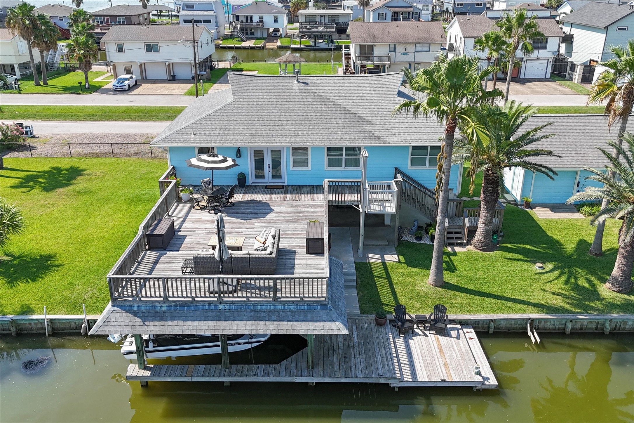 A stunning aerial view highlights this spacious home, featuring a large upper party deck, a convenient garage, and an adjacent empty lot offering endless possibilities. Perfect for entertaining and expansion in a prime location. A stunning aerial view highlights this spacious home, featuring a large upper party deck, a convenient garage, and an adjacent empty lot offering endless possibilities. Perfect for entertaining and expansion in a prime location.