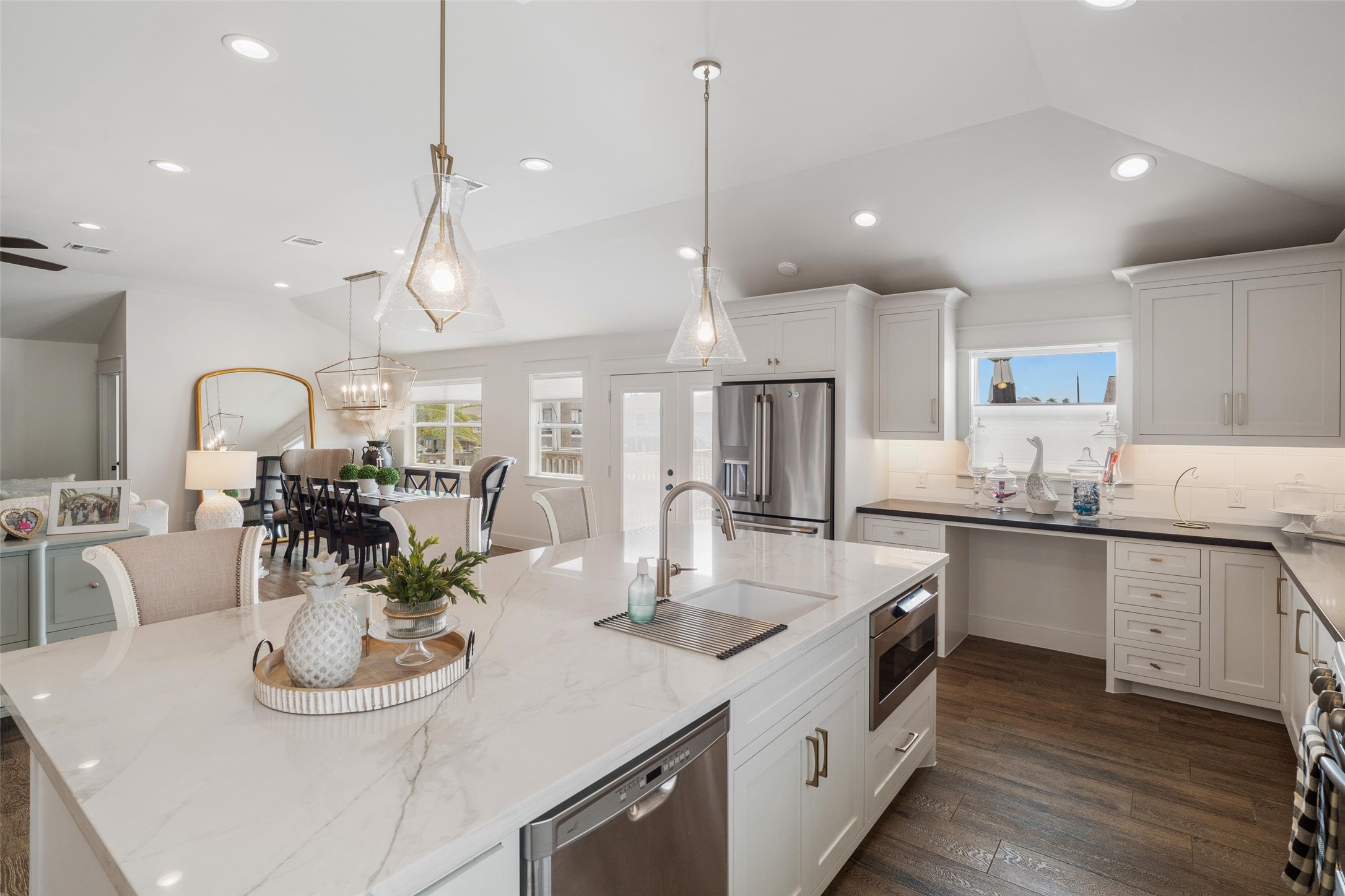 Spacious kitchen island with custom modern pendant lighting, overlooking the open dining and living rooms.