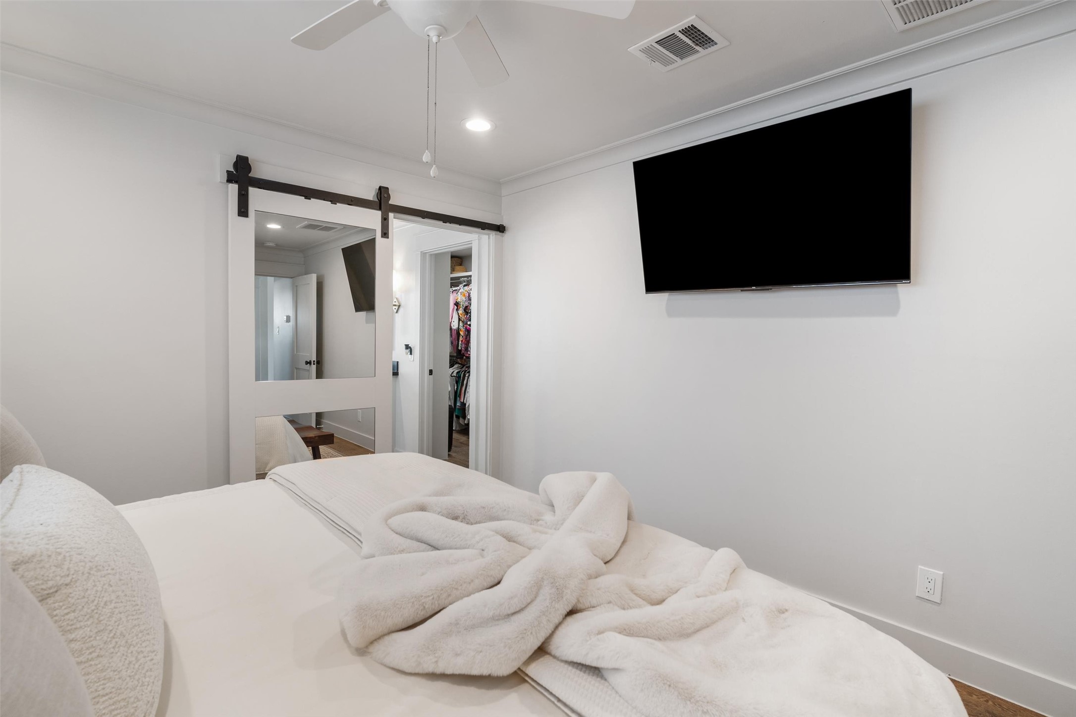 View of the modern sliding barn door into the walk in closet and primary ensuite