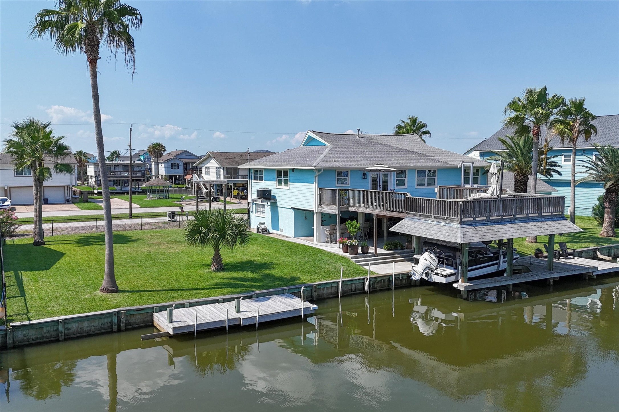 Aerial view showing the extra lot with palm trees. There's even an additional dock on the lot