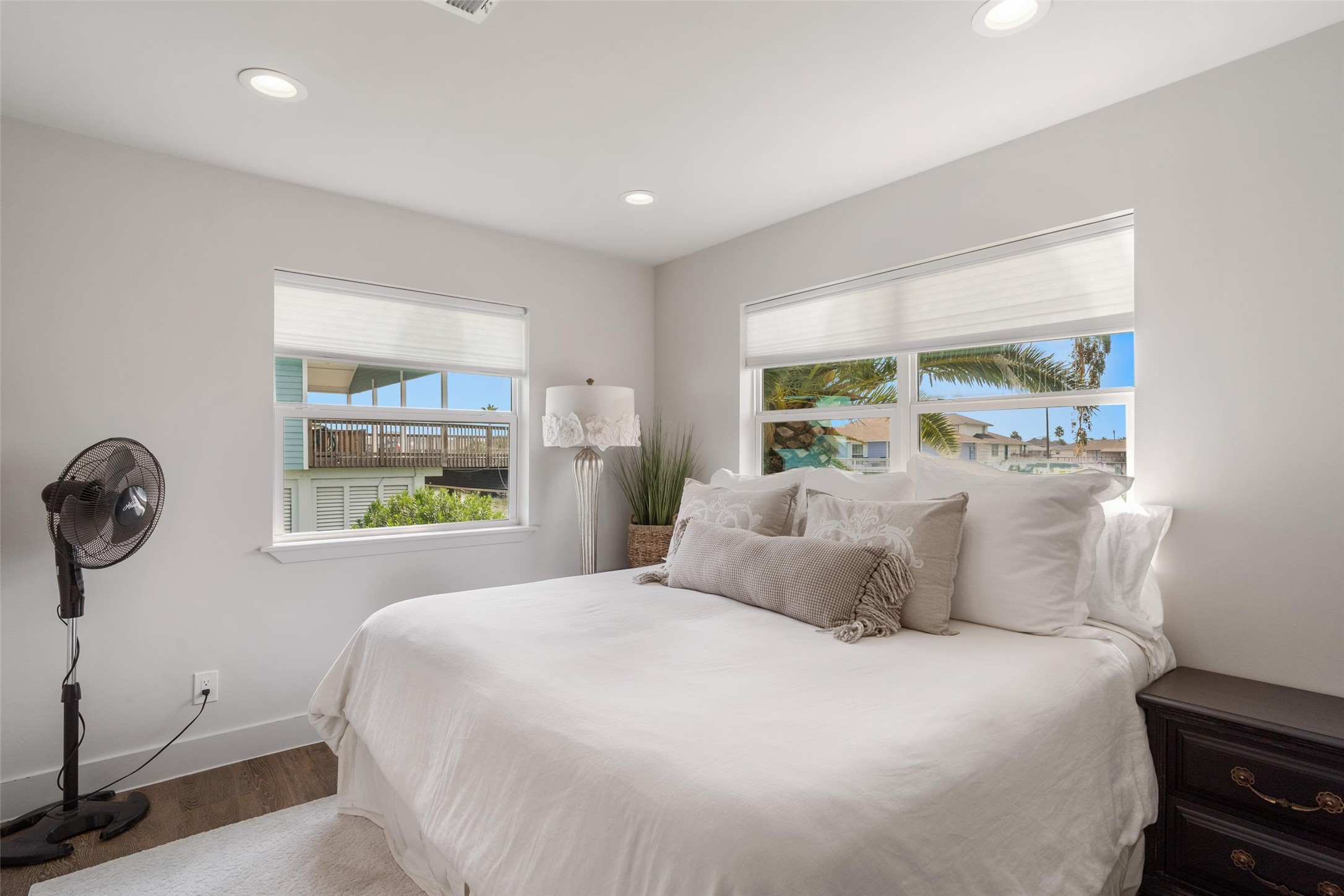 Bright guest bedroom on the water side of the home features stunning views, abundant natural light, and soothing dcor