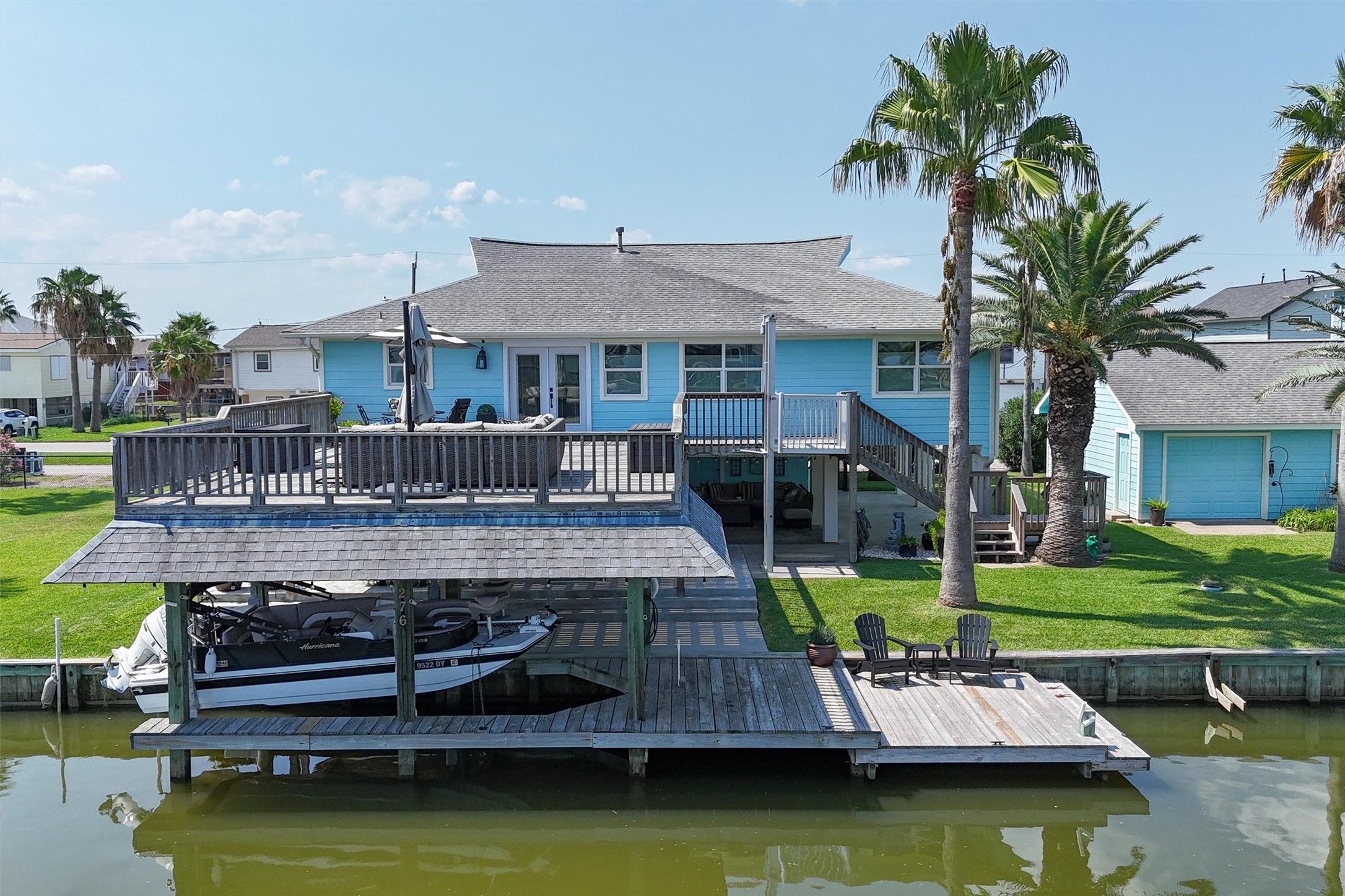 The oversized upper party deck on this east-facing property is the ultimate gathering spot, surrounded by beautiful palm trees that create a perfect tropical ambiance. Enjoy ample space for fishing from the dock and easy boat access with your own private slip The oversized upper party deck on this east-facing property is the ultimate gathering spot, surrounded by beautiful palm trees that create a perfect tropical ambiance. Enjoy ample space for fishing from the dock and easy boat access with your own private slip