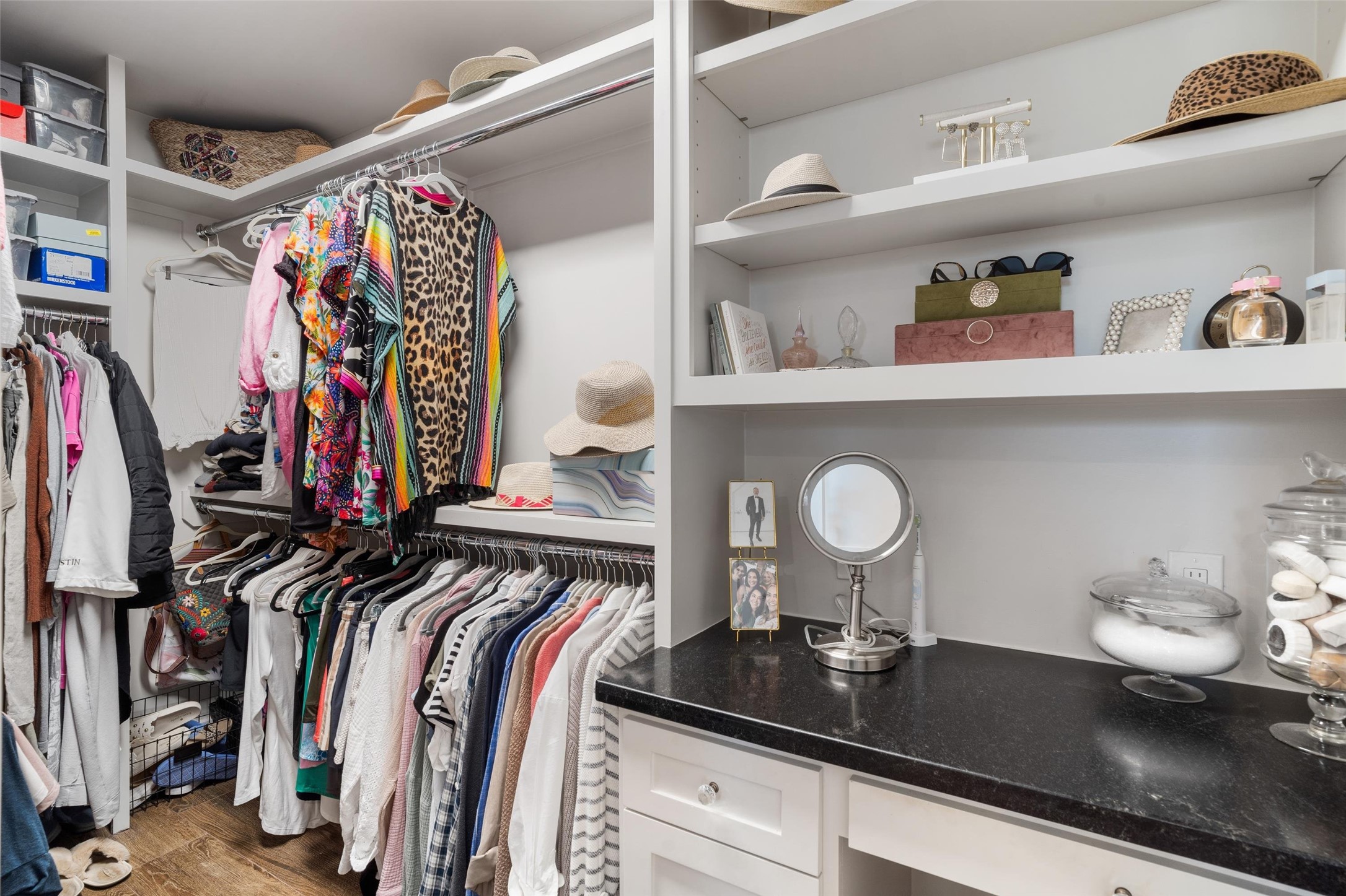 Expansive primary walk-in closet with custom built-ins and a beautifully designed makeup vanity, offering both elegance and functionality for organized, everyday living