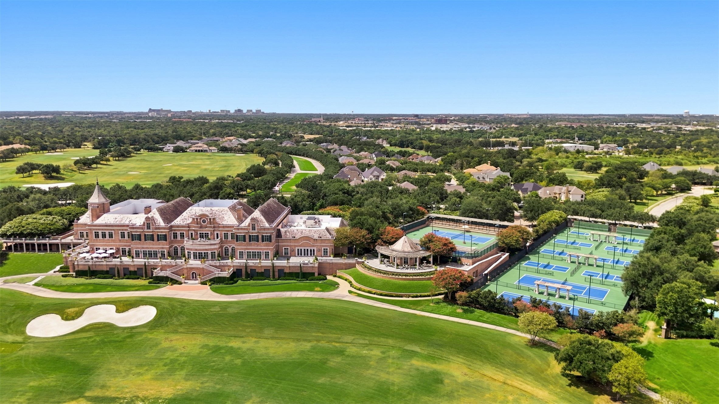 Aerial view of Miramont Country Club featuring the clubhouse, championship golf course, tennis courts, and pickleball courts.