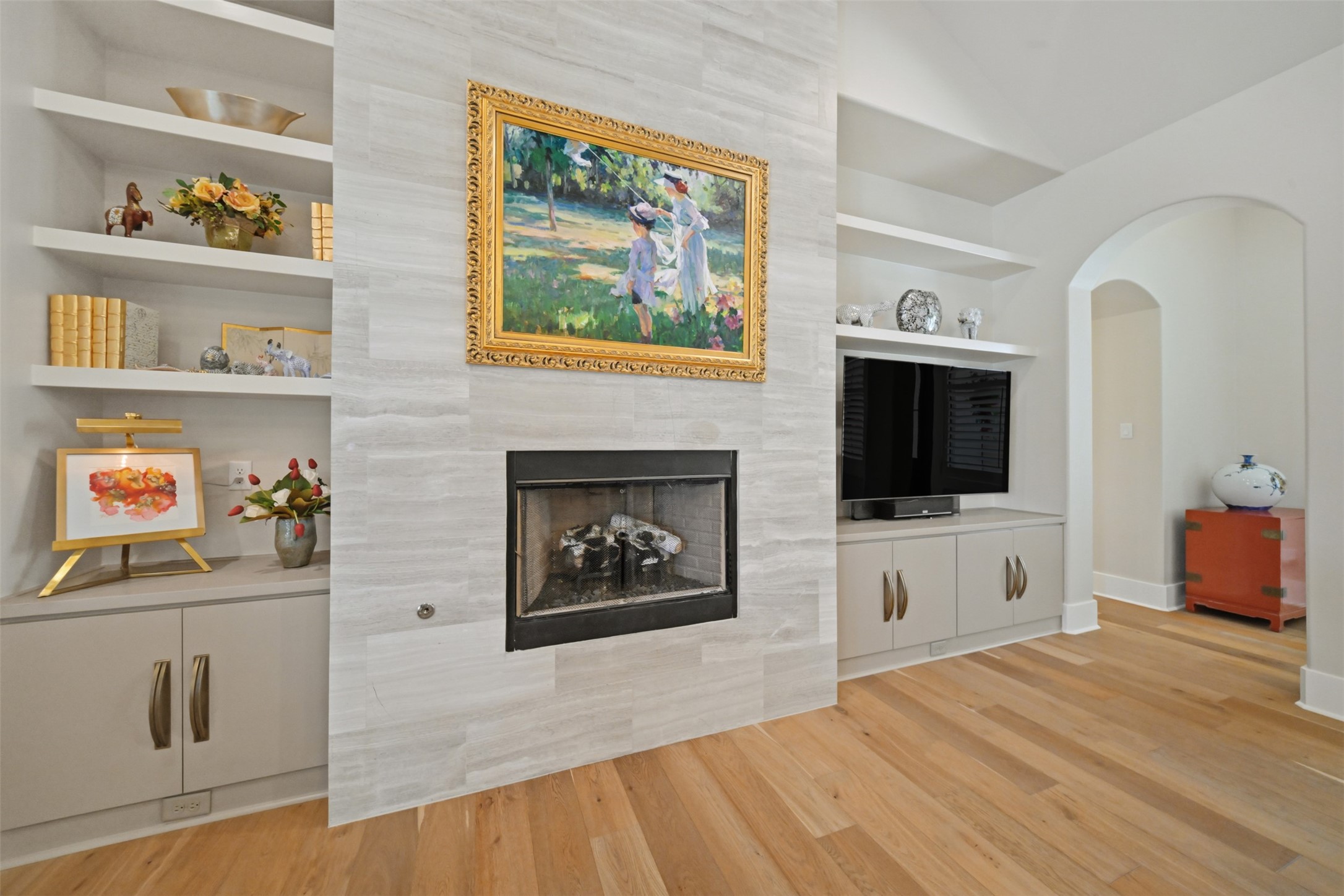 Great room featuring a gas-log fireplace flanked by custom built-ins and cabinetry.