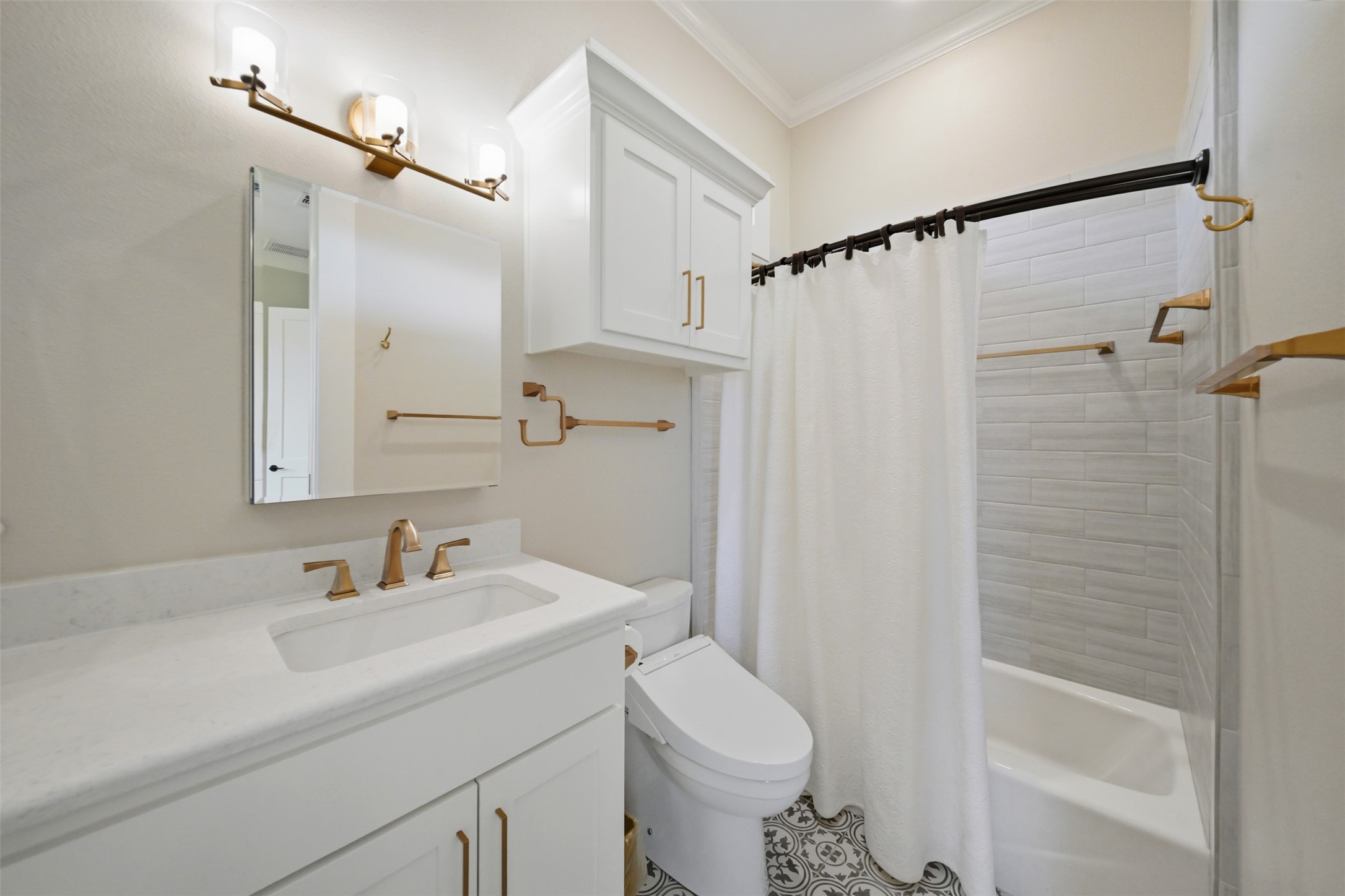 En suite bath featuring custom cabinetry, stylish fixtures and tub/shower combination.