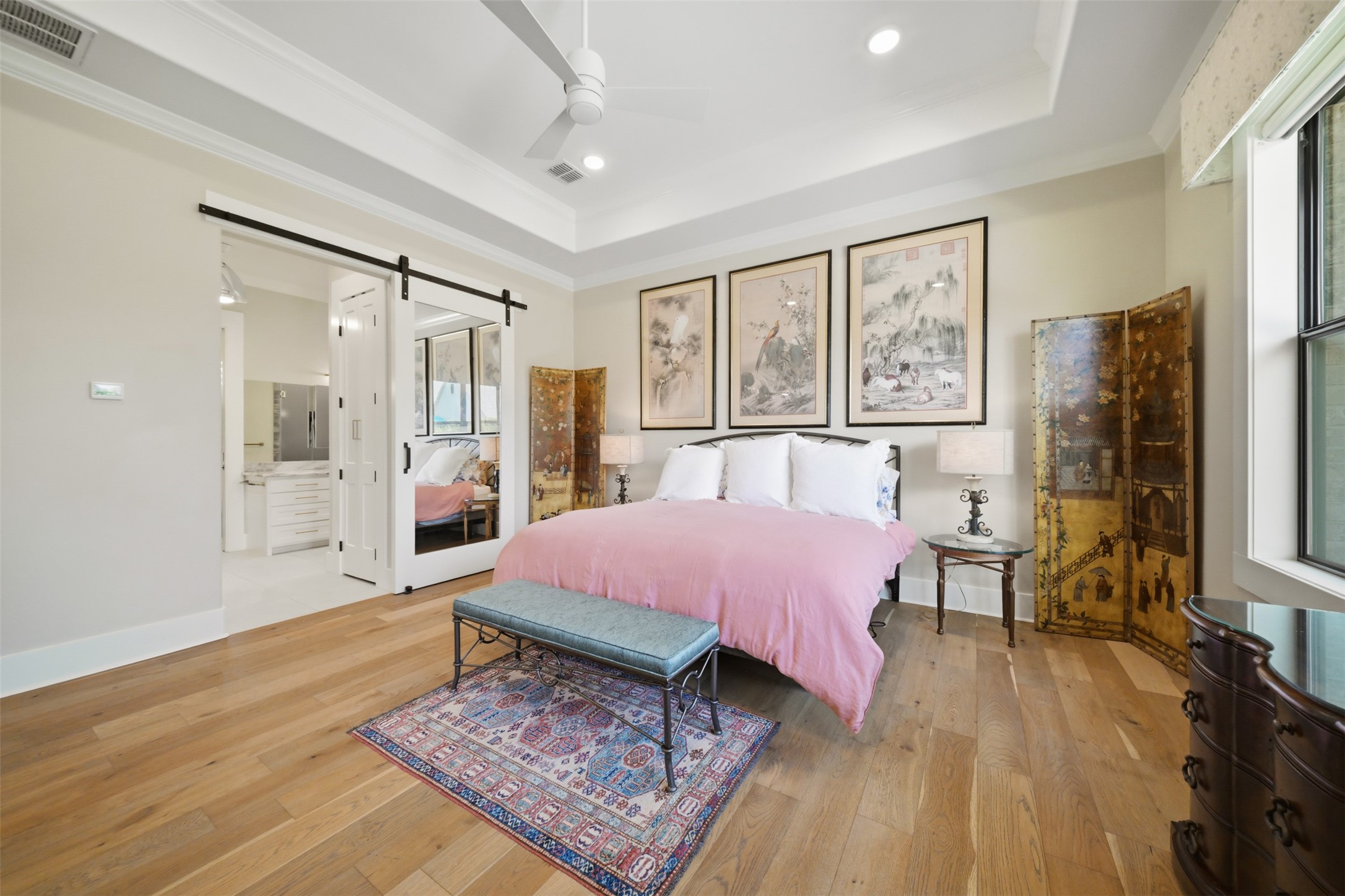 Spacious primary suite with hardwood floors and private en suite bath.