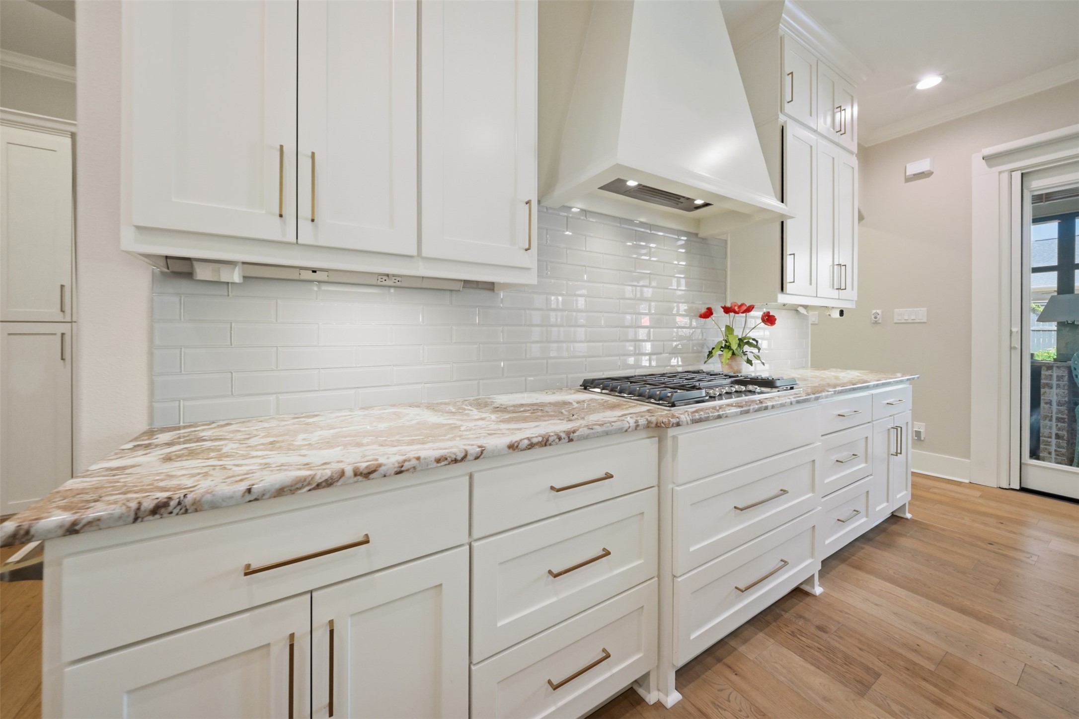 Beautifully appointed kitchen with custom vent hood, 5 burner gas cooktop and abundant custom cabinetry.