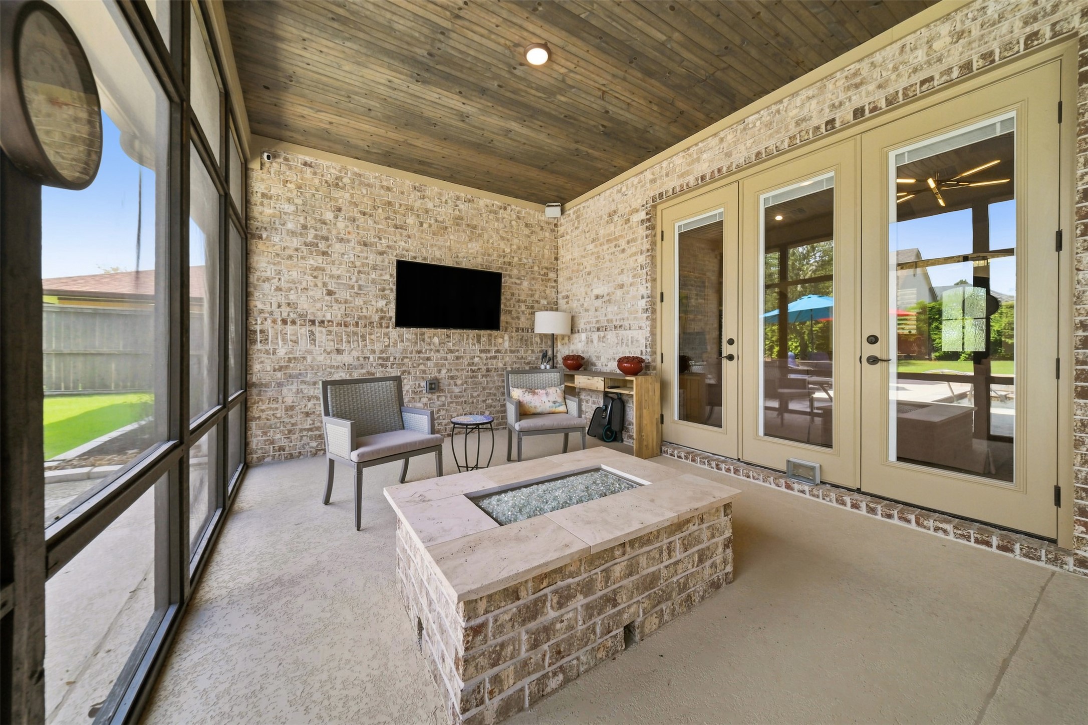 Inviting screened-in porch with a built-in fire pitperfect for year-round outdoor living and entertaining.