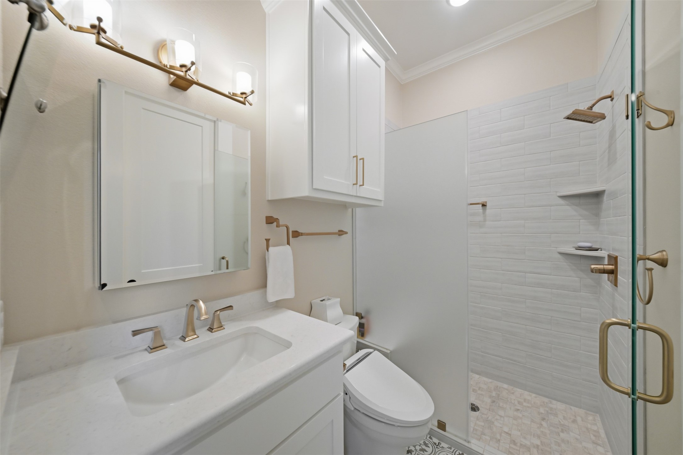 Secondary en suite bath with custom cabinetry, walk-in shower and adjoining walk-in closet.
