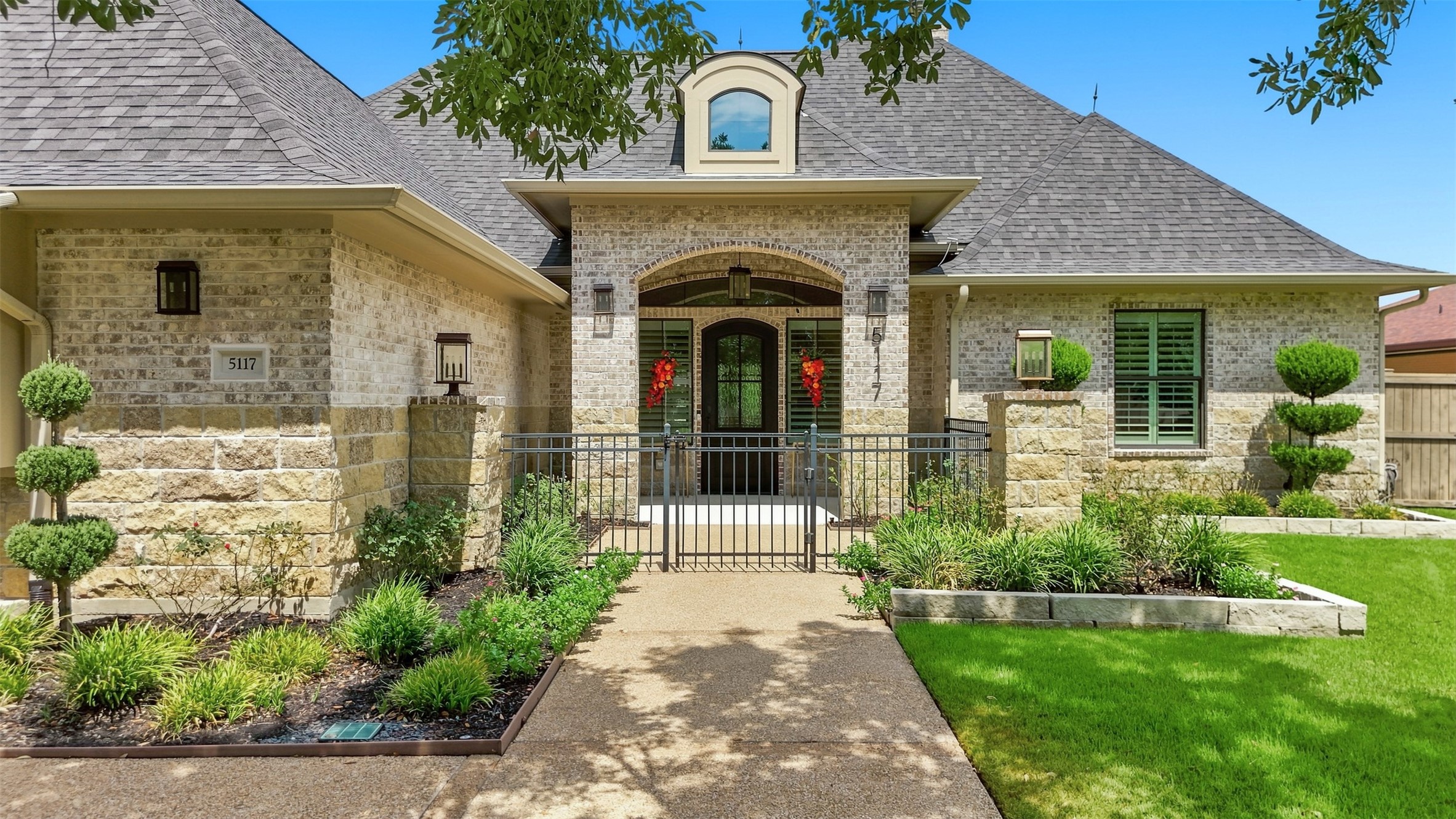 Gated front courtyard creates a welcoming entrance leading to the striking metal front door.