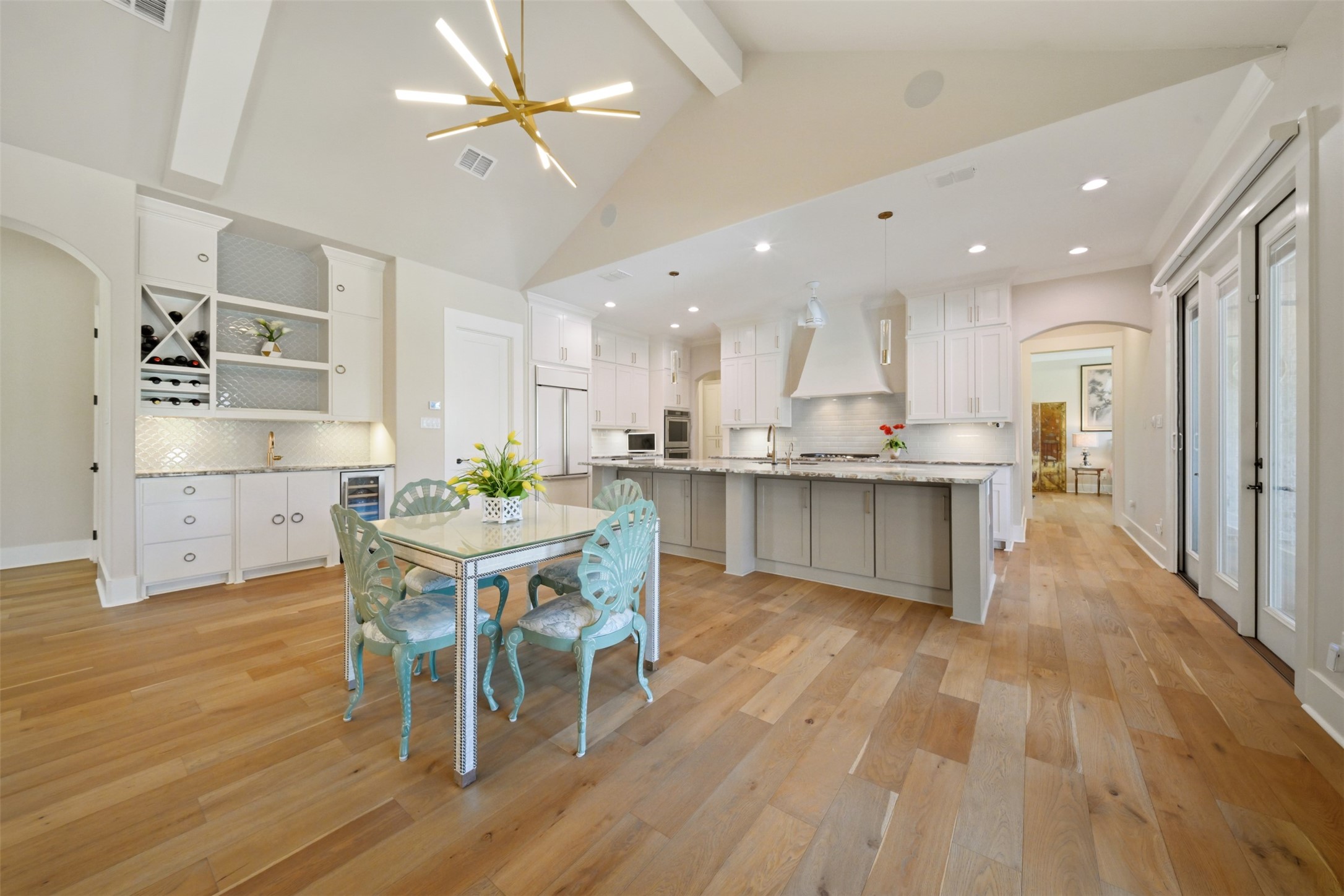 Generous dining area conveniently located between the kitchen and wet bar, with an oversized island offering additional bar seating.