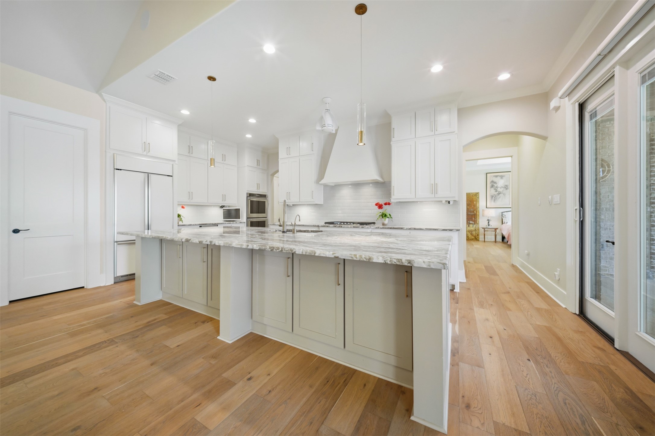 Spacious kitchen with built-in refrigerator, oversized island with seating and an open view from the great room.