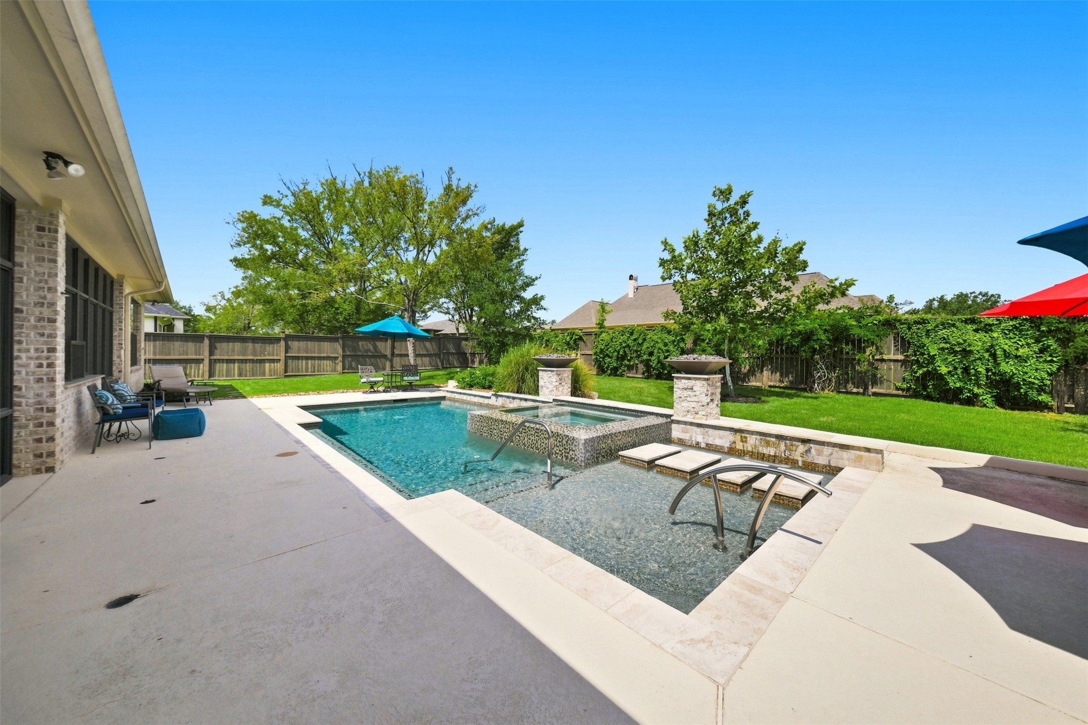 Resort-style pool with a spacious sun shelf and multiple areas for lounging, relaxing and entertaining.