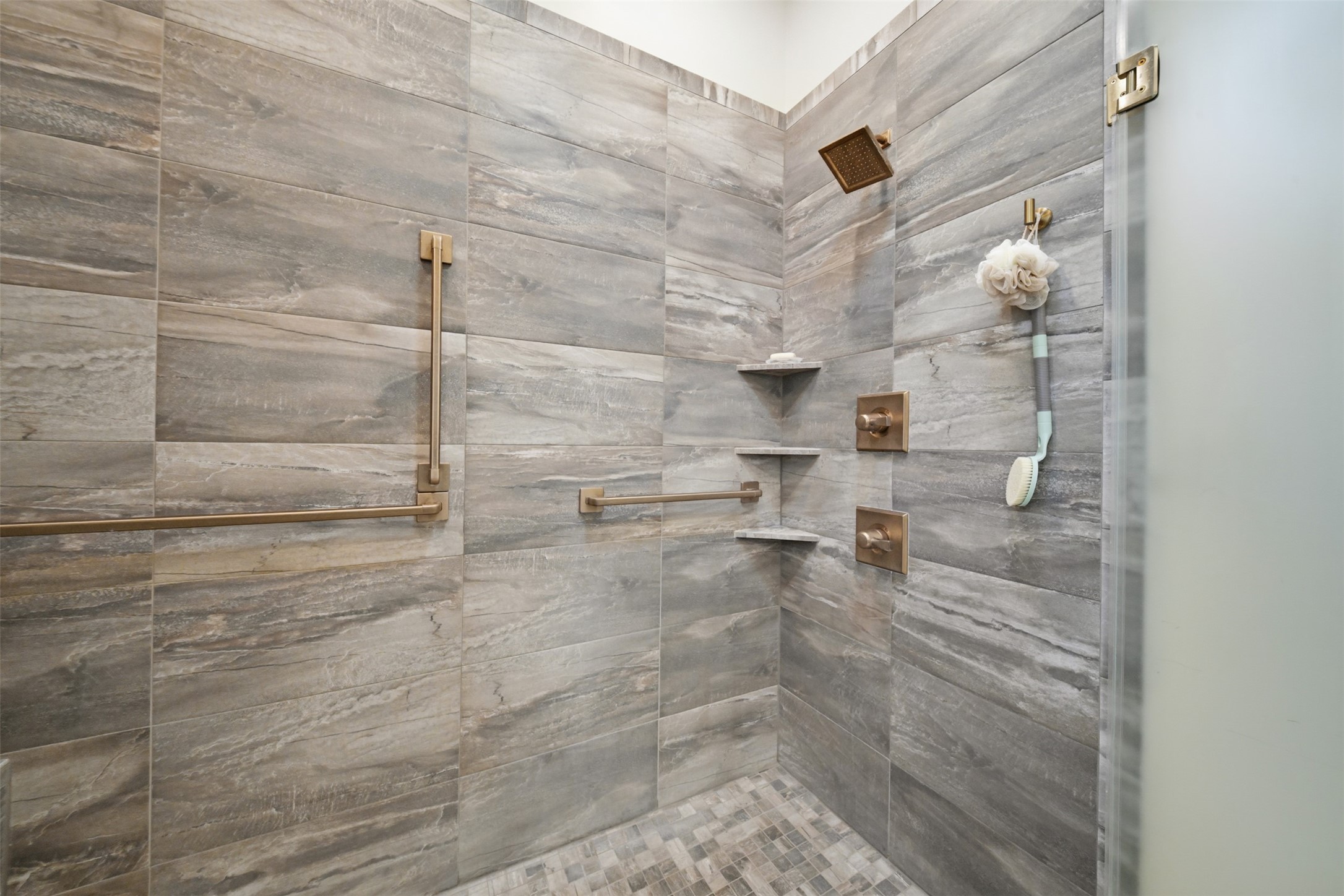 Luxurious walk-in shower featuring beautiful stonework and custom fixtures.