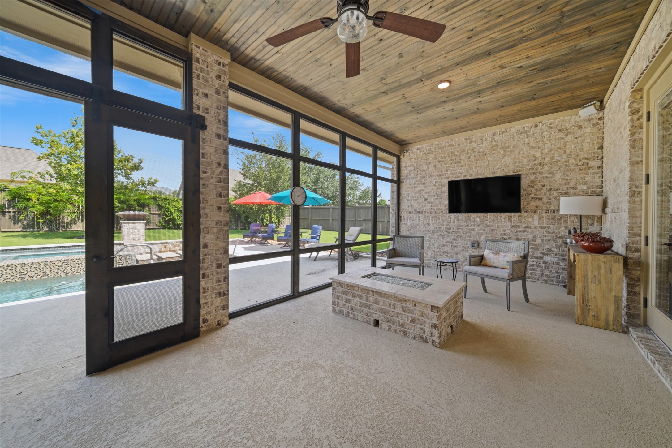 Built-in fire pit creates a cozy gathering space within the expansive screened-in patio, just steps from the pool.