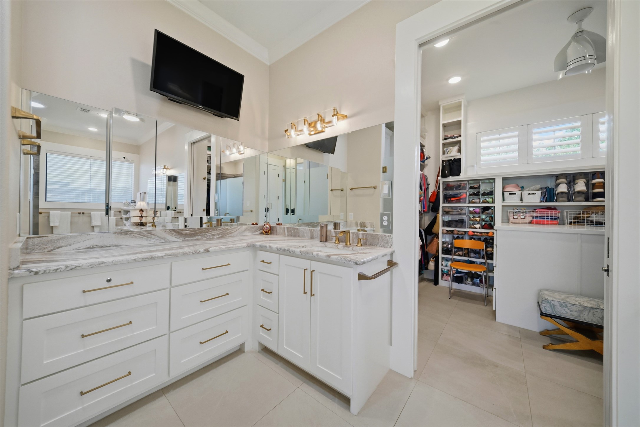 Primary bath featuring separate vanities with abundant custom cabinetry and storage.