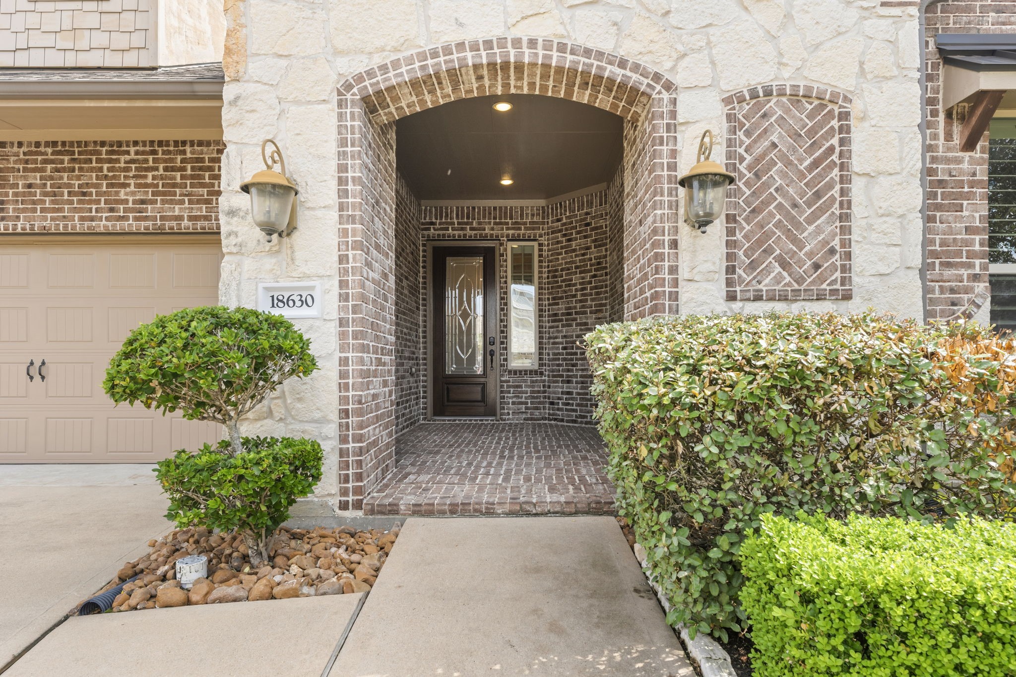Charming stone and brick entryway with arched design and well-maintained landscaping, creating a welcoming entrance to the home. Charming stone and brick entryway with arched design and well-maintained landscaping, creating a welcoming entrance to the home.
