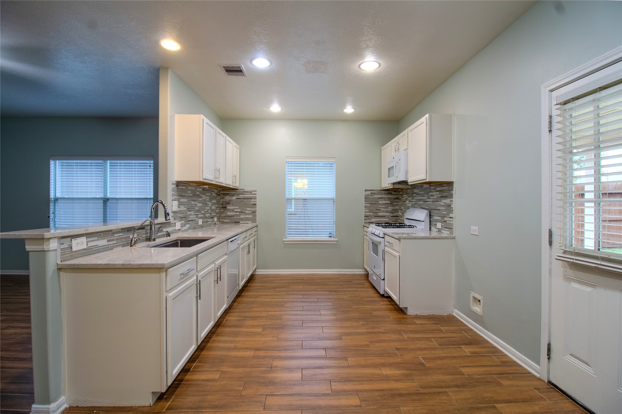 The updated kitchen features beautiful granite countertops complemented by a stylish coordinating backsplash, creating a modern and functional space for cooking and entertaining.
