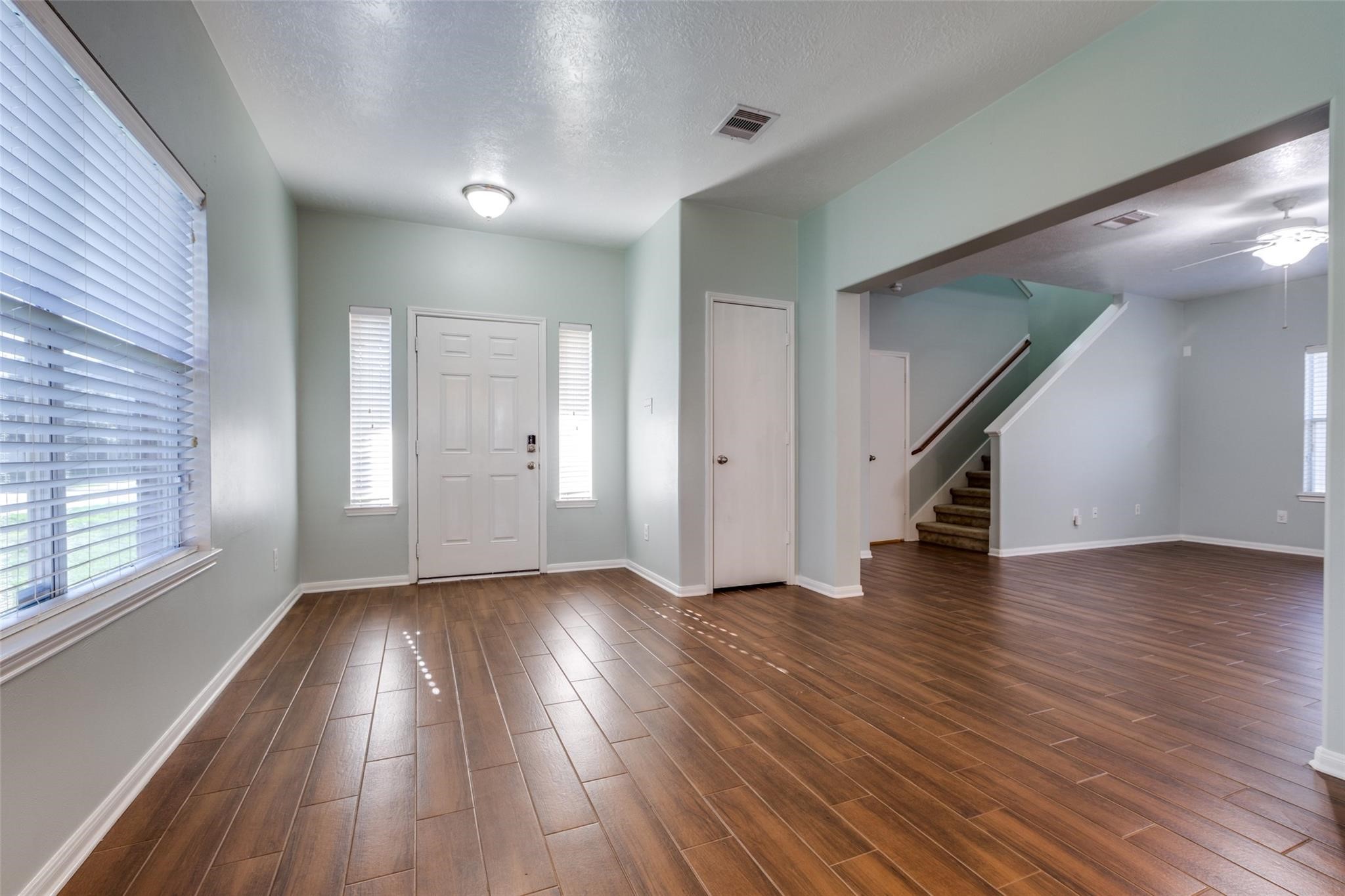 Step into a welcoming entry foyer featuring beautiful wood-look tile flooring that flows seamlessly throughout the entire first floor, offering both style and durability. Just beyond the