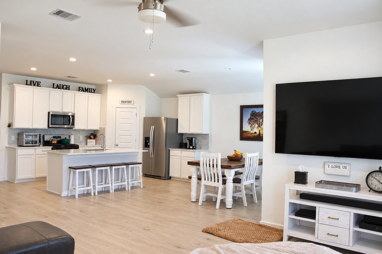 Open-Concept Living, Dining, and Kitchen Area with Modern Finishes and Wood-Look Flooring.