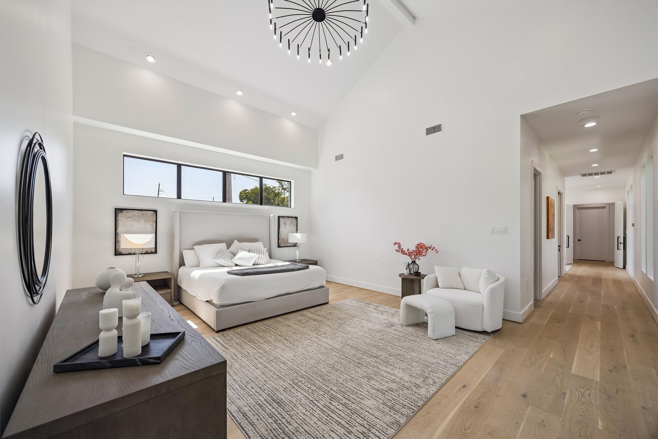 A sanctuary of understated elegance, the spacious primary suite features soaring ceilings, a statement chandelier, and beautifully proportioned interiors designed for comfort and tranquility.