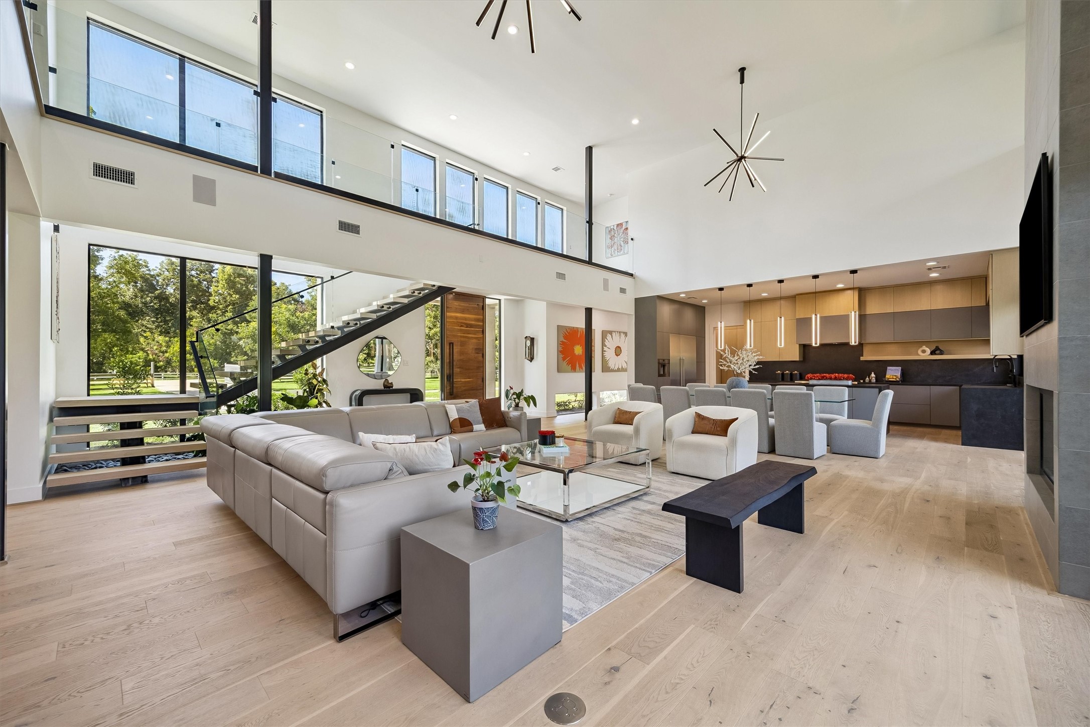 Beautifully connected living, dining, and kitchen spaces encourage effortless entertaining, with expansive windows and thoughtfully curated finishes enhancing the home's open, airy atmosphere.