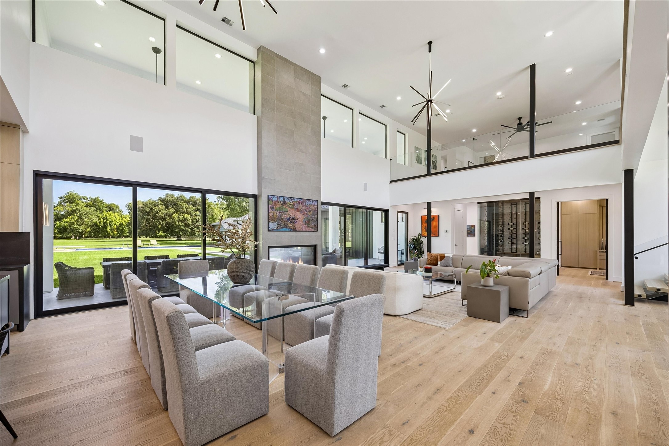 Expansive walls of glass dissolve the boundaries between indoors and out, framing picturesque views of the grounds while filling the grand living and dining spaces with natural light. Expansive walls of glass dissolve the boundaries between indoors and out, framing picturesque views of the grounds while filling the grand living and dining spaces with natural light.