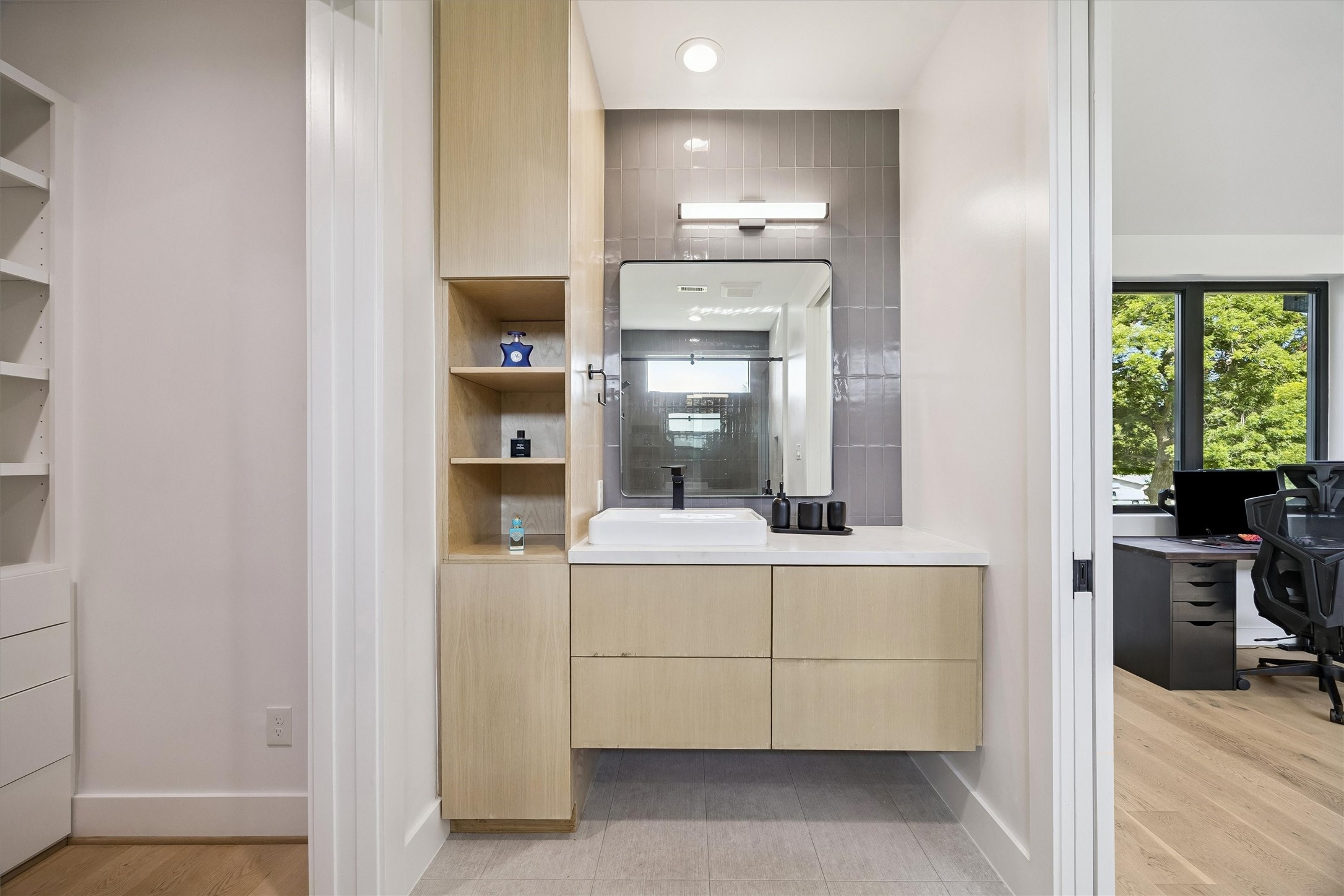 A thoughtfully appointed bathroom features streamlined cabinetry, modern lighting, and an elegant vanity, offering both beauty and everyday convenience.