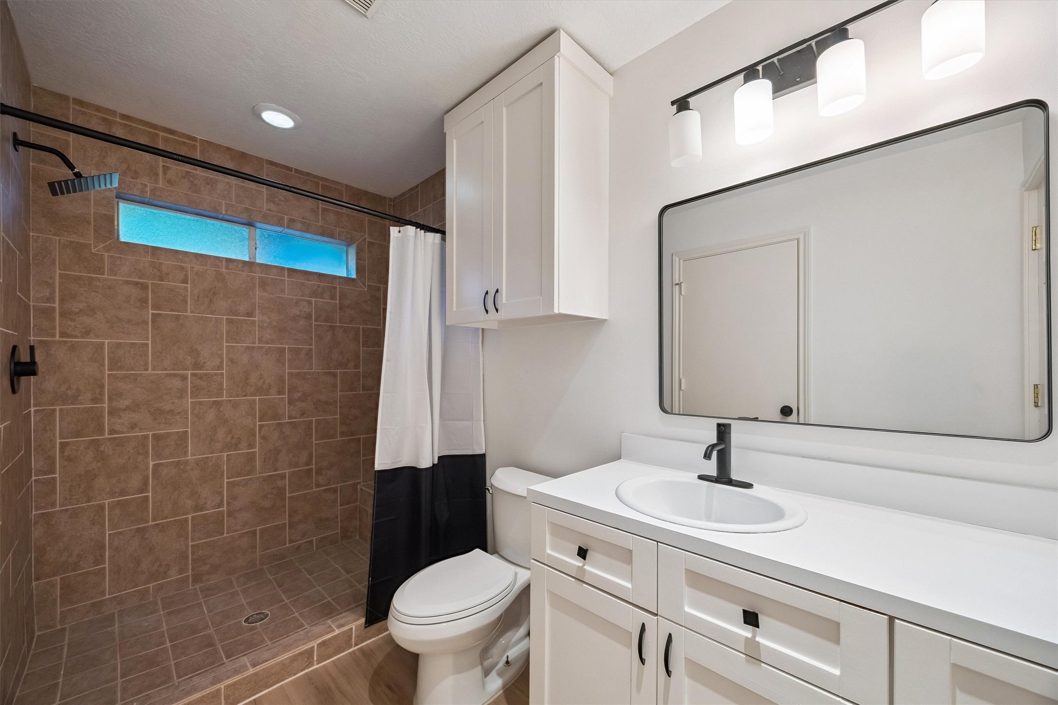 A beautifully updated bathroom enhances the comfort and functionality of the detached pool house, featuring a spacious shower, elegant vanity, and contemporary finishes.
