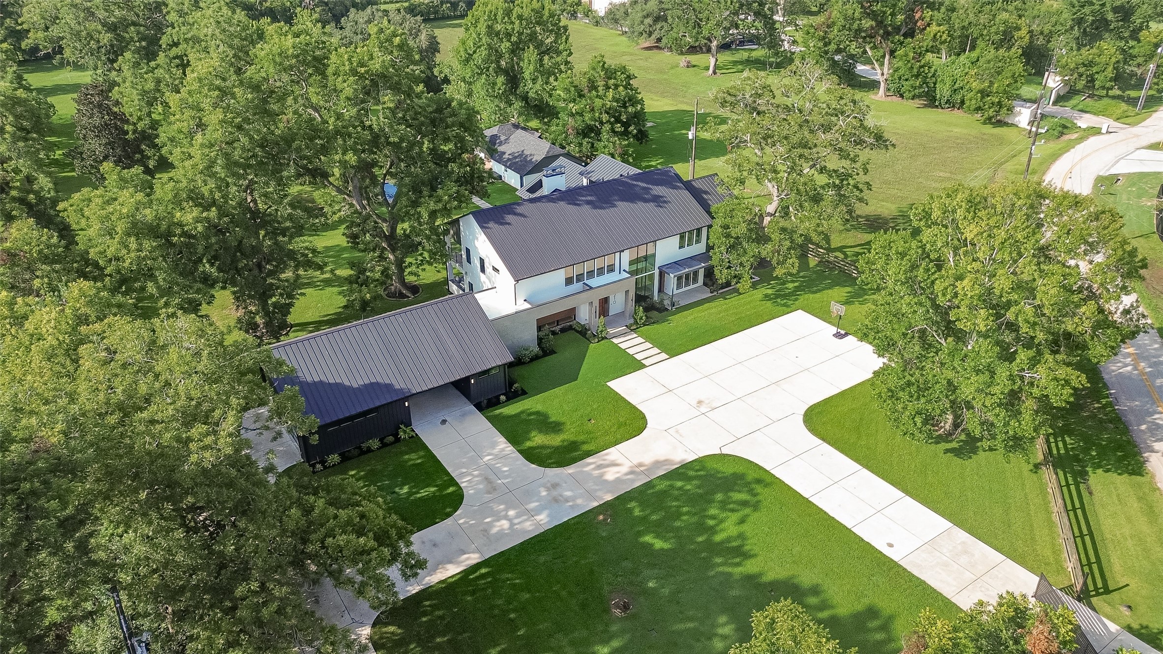 An elevated perspective reveals the home's distinctive architecture, generous motor court, and beautifully landscaped setting, offering an early glimpse of the privacy and scale that define this exceptional property. An elevated perspective reveals the home's distinctive architecture, generous motor court, and beautifully landscaped setting, offering an early glimpse of the privacy and scale that define this exceptional property.