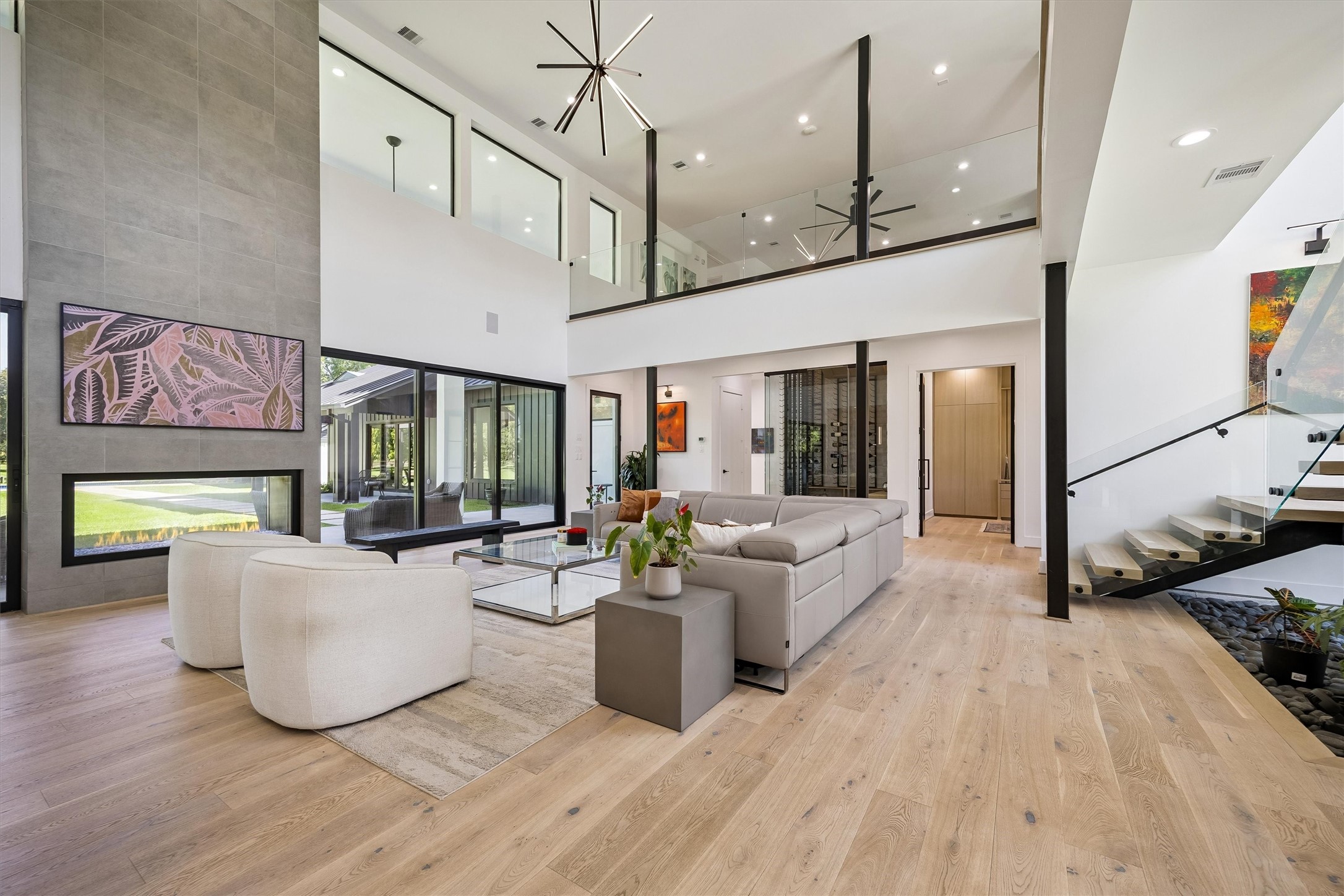 A striking fireplace anchors this spectacular gathering space, where towering ceilings and oversized windows create a captivating balance of warmth, elegance, and modern design. A striking fireplace anchors this spectacular gathering space, where towering ceilings and oversized windows create a captivating balance of warmth, elegance, and modern design.