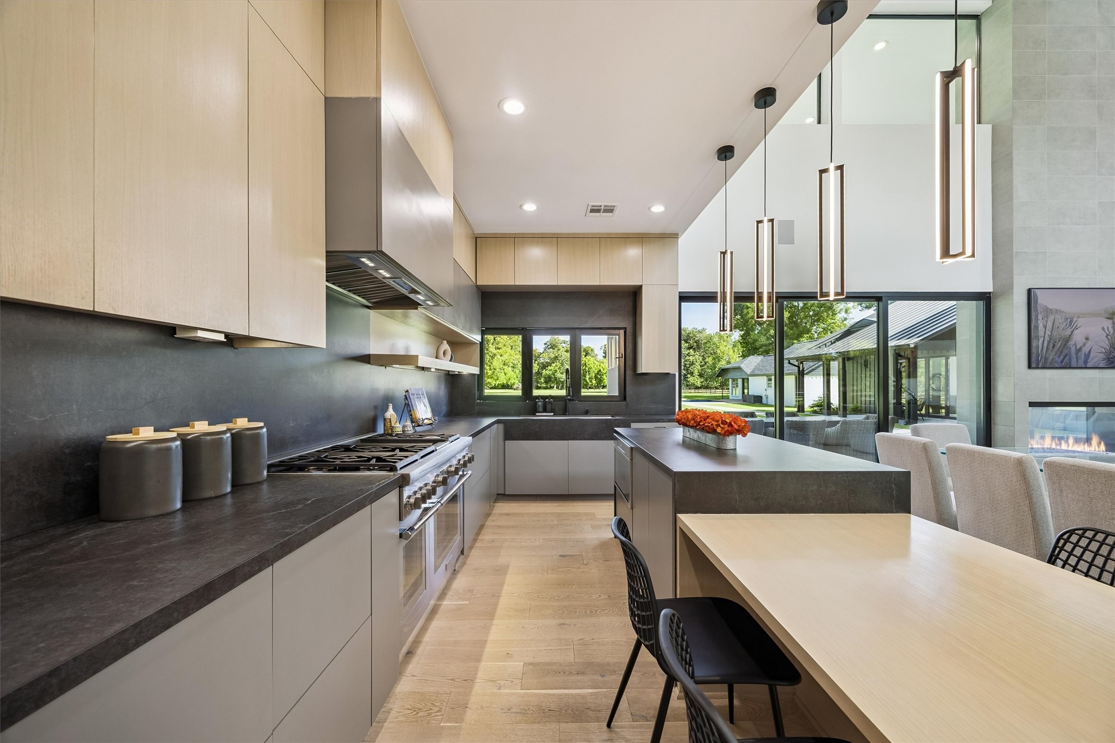 Clean architectural lines, elegant cabinetry, generous counter space, and contemporary lighting establish a refined culinary environment, thoughtfully integrated into the home's open-concept design.
