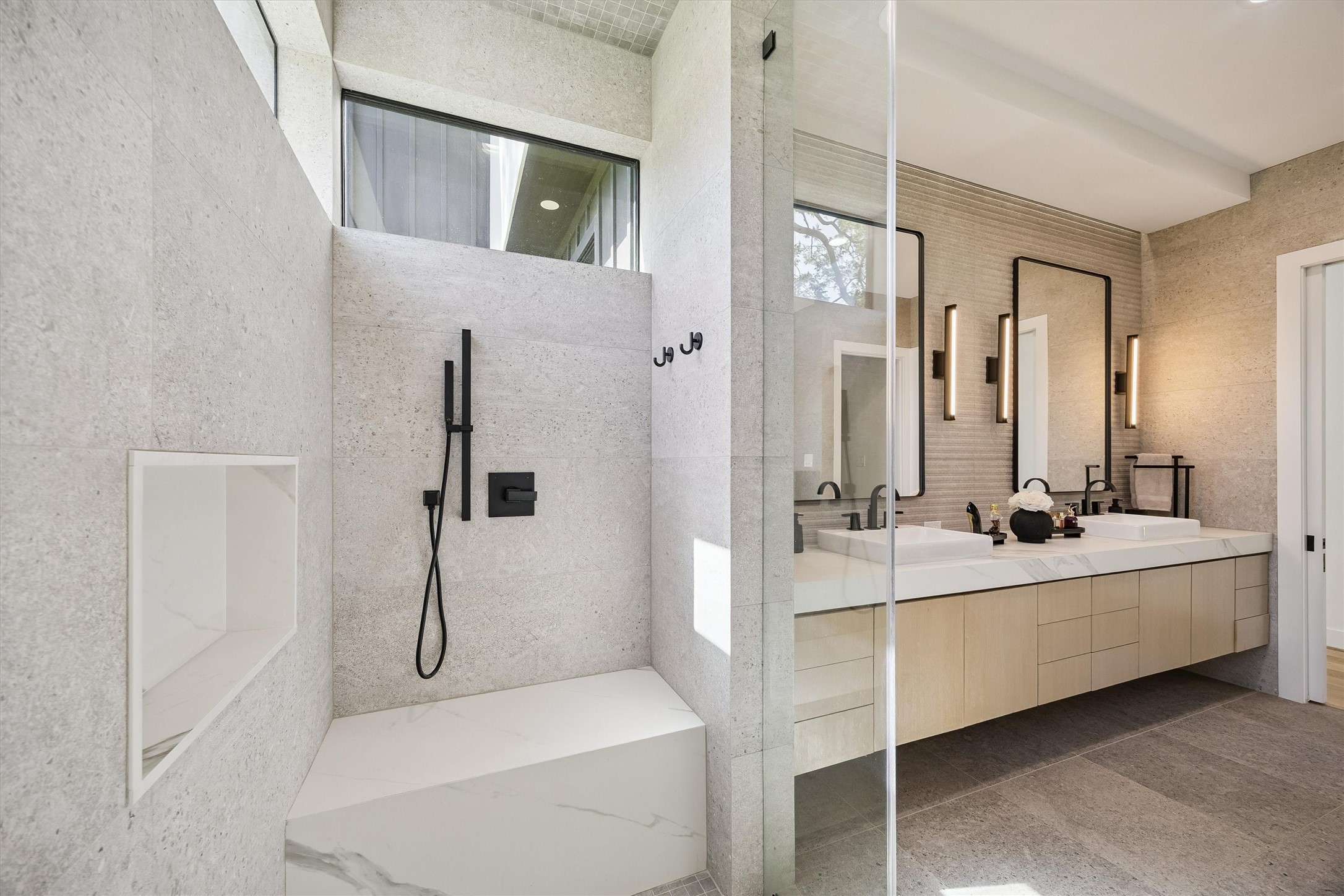 A beautifully designed shower showcases sophisticated tilework, sleek black fixtures, and seamless glass, bringing the tranquility of a private spa into the comfort of home.