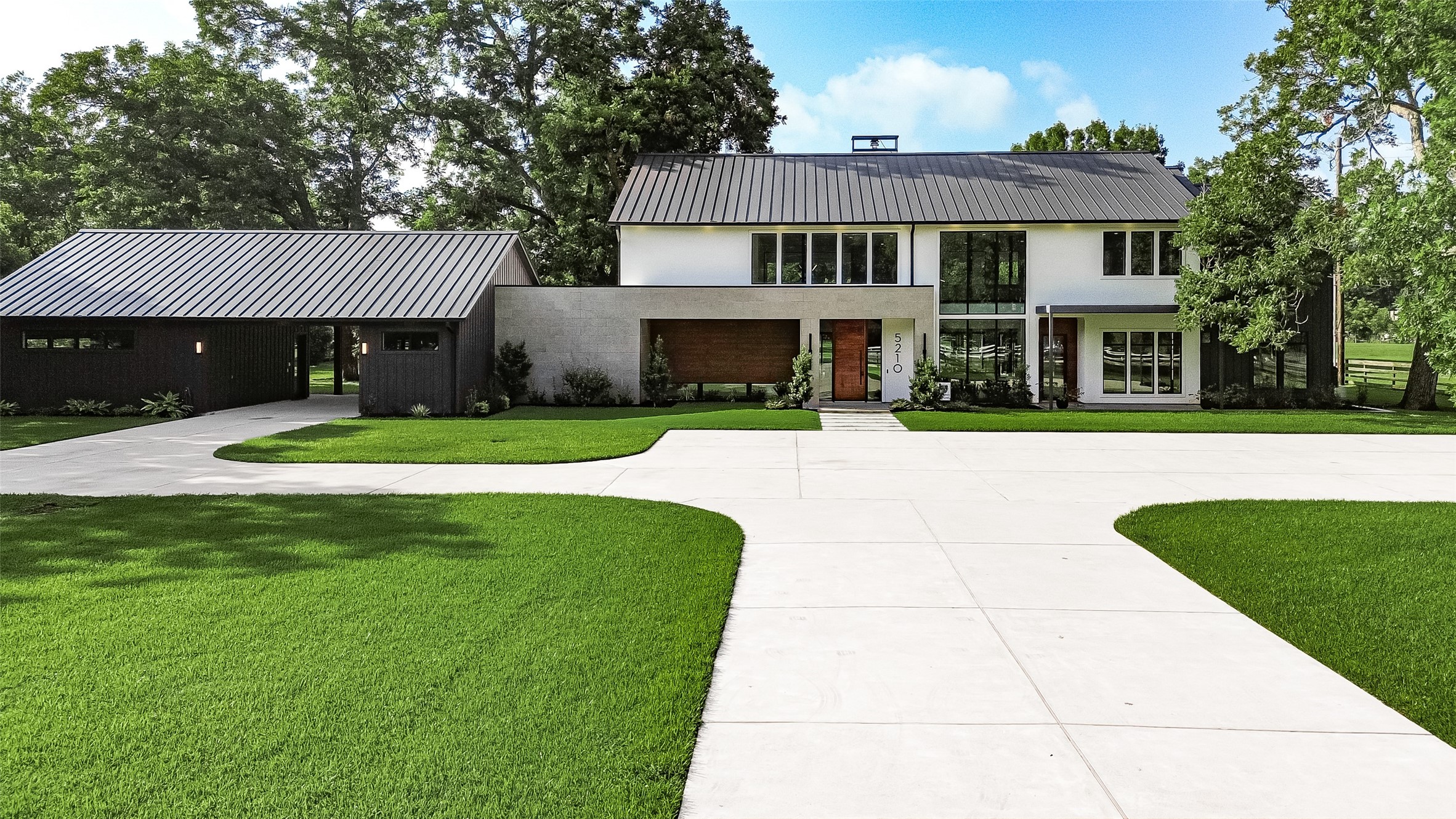 Striking contemporary architecture meets timeless sophistication, with a distinctive metal roof, dramatic windows, and beautifully maintained lawns creating an unforgettable first impression. Striking contemporary architecture meets timeless sophistication, with a distinctive metal roof, dramatic windows, and beautifully maintained lawns creating an unforgettable first impression.