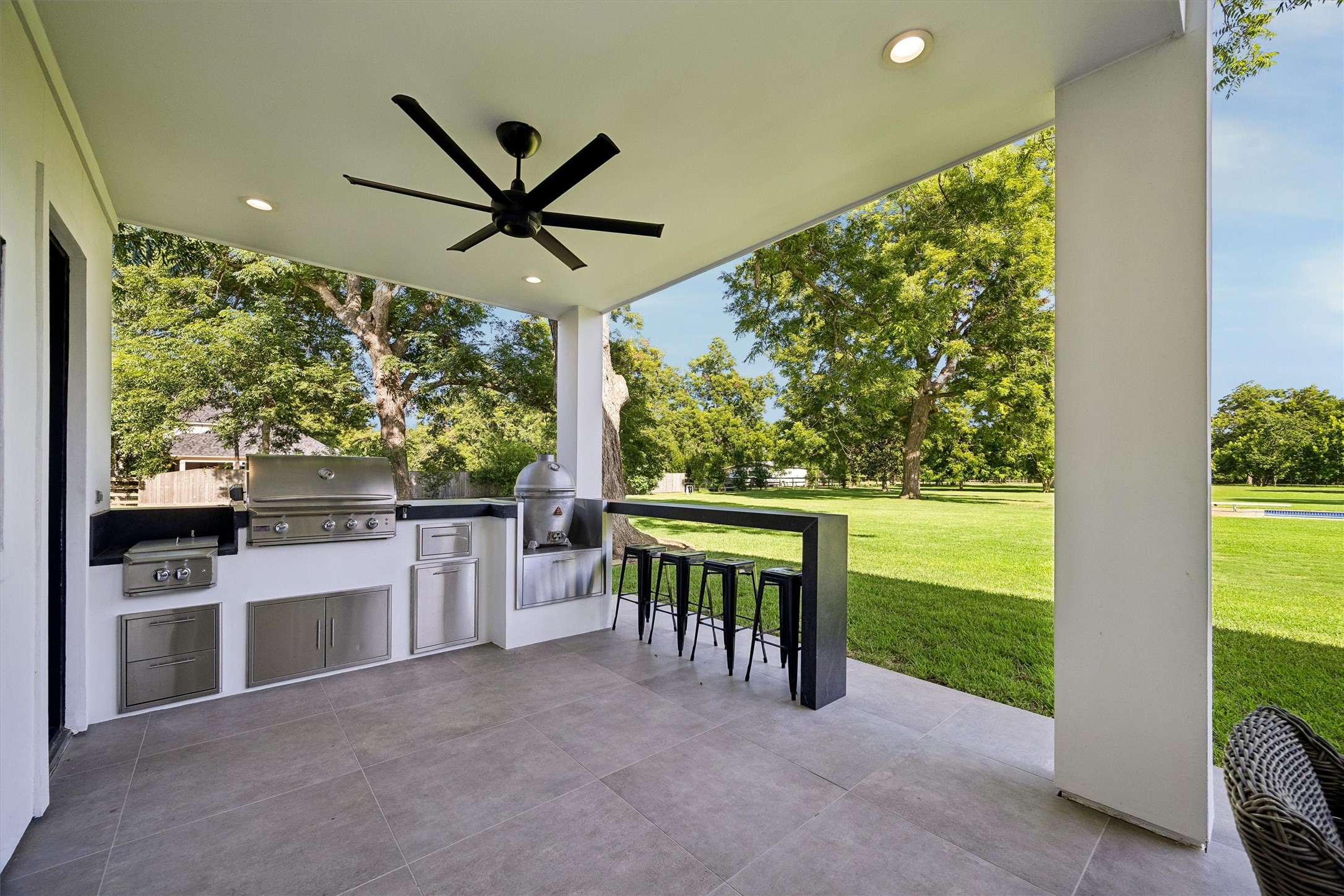 Entertain in style beneath a spacious covered pavilion featuring a built-in grill, generous preparation counters, and bar seatingall overlooking the expansive grounds.
