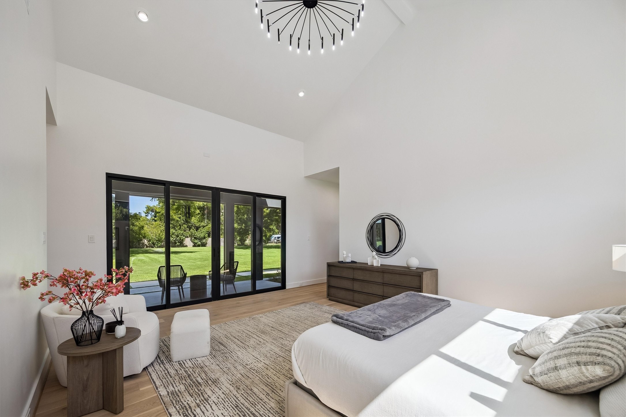 Expansive glass doors extend the primary bedroom toward the outdoors, creating a beautiful connection between this private retreat and the estate's lush surroundings.