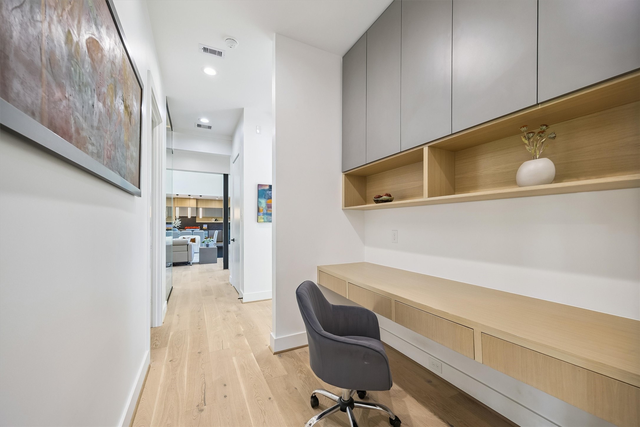 A custom built-in workstation transforms this transitional space into a functional and stylish retreat, with integrated cabinetry and shelving that maximize both convenience and organization.